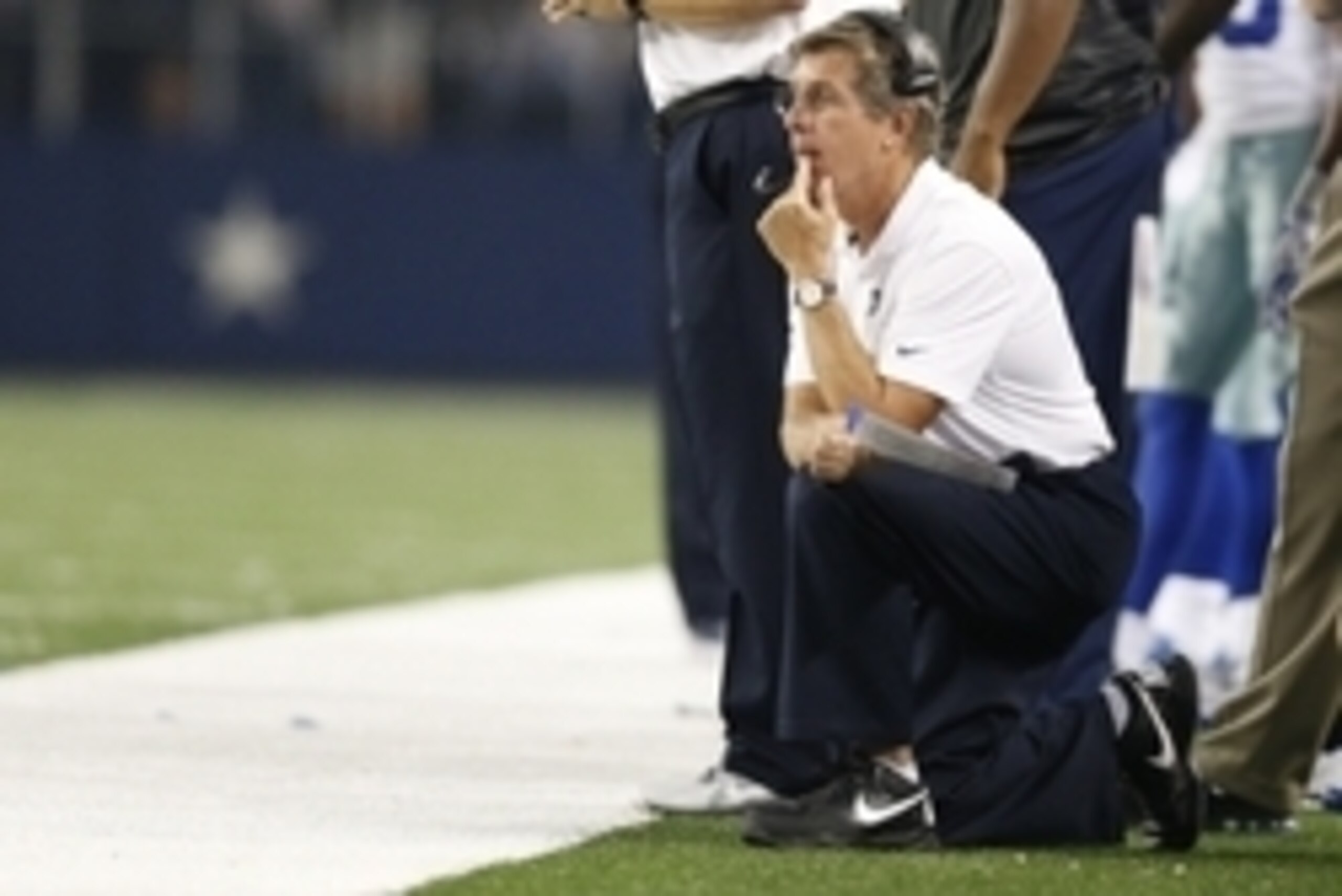 Oct 27, 2014; Arlington, TX, USA; Dallas Cowboys offensive coordinator Bill Callahan kneels on the sidelines against the Washington Redskins at AT&T Stadium. Mandatory Credit: Matthew Emmons-USA TODAY Sports