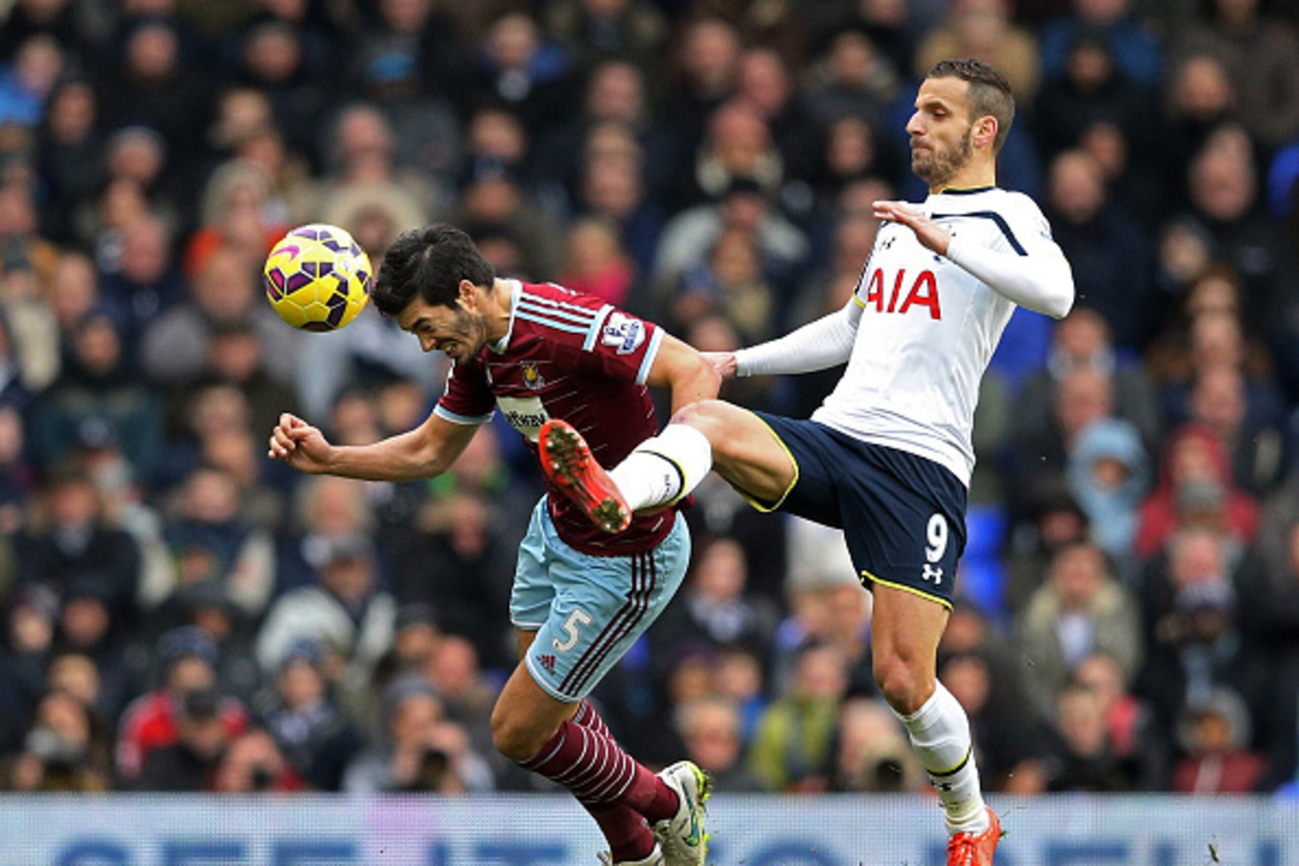 LONDON, ENGLAND - FEBRUARY 22:  James Tomkins of West Ham heads the ball under pressure from Roberto Soldado of Spurs during the Barclays Premier League match between Tottenham Hotspur and West Ham United at White Hart Lane on February 22, 2015 in London,