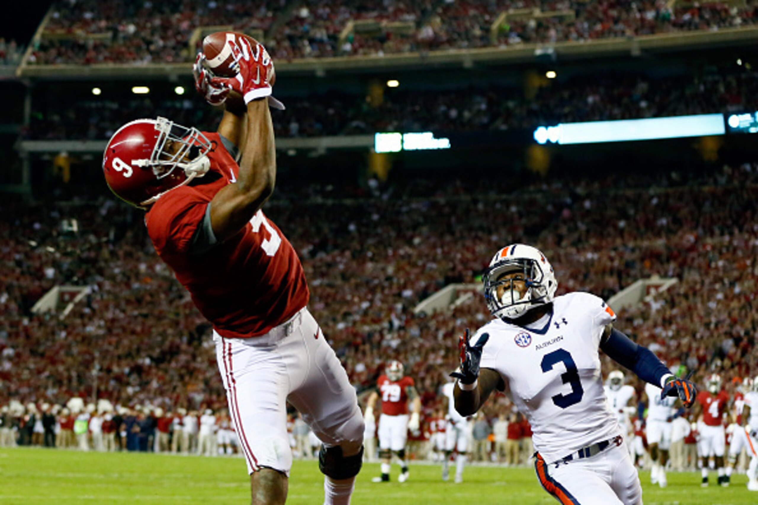 TUSCALOOSA, AL - NOVEMBER 29:  Amari Cooper #9 of the Alabama Crimson Tide catches a 17 yard touchdown pass from Blake Sims #6 in the first quarter against Jonathan Jones #3 of the Auburn Tigers during the Iron Bowl at Bryant-Denny Stadium on November 29,