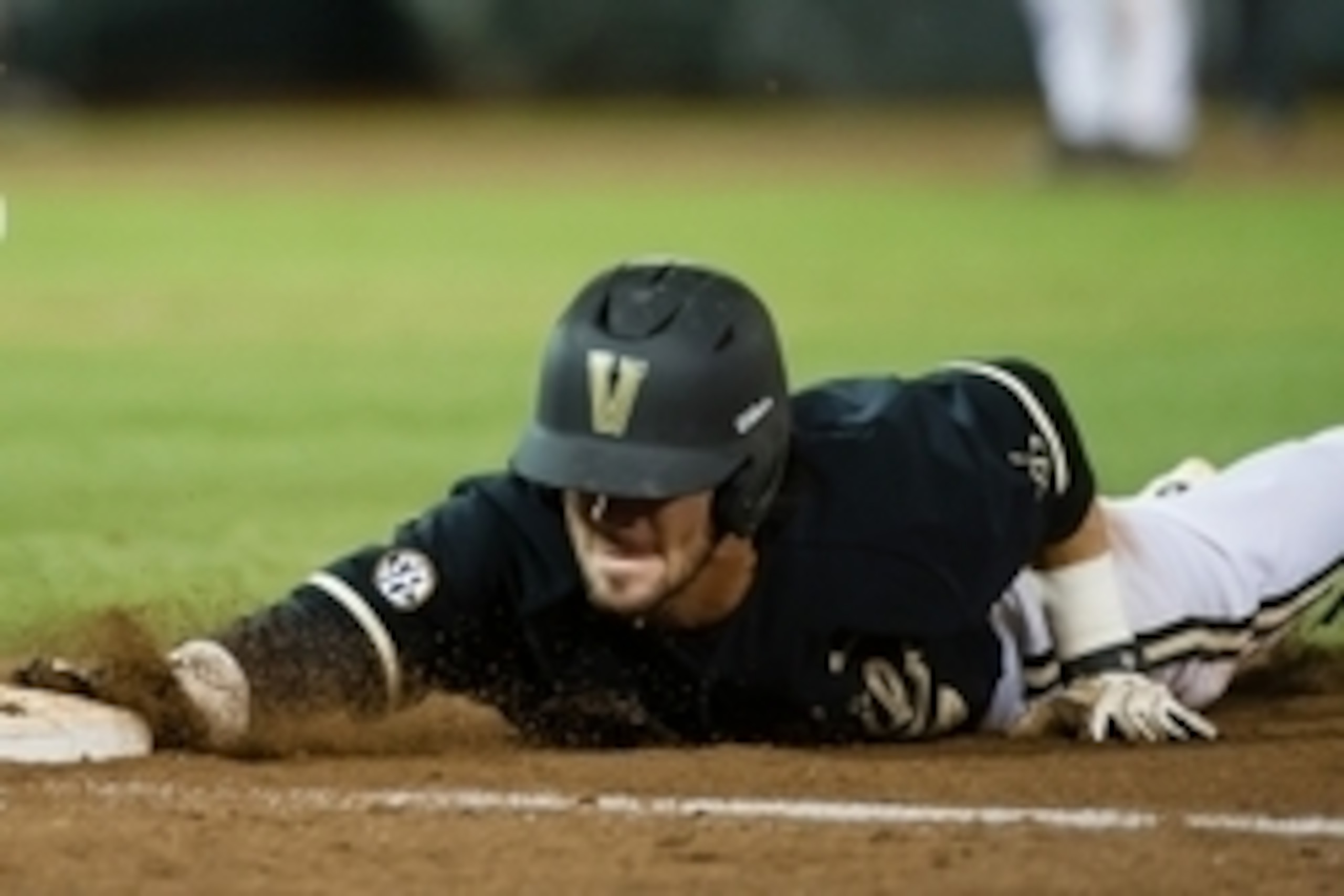 Jun 25, 2014; Omaha, NE, USA; Vanderbilt Commodores infielder Dansby Swanson (7) slides back into first base against the Virginia Cavaliers during game three of the College World Series Finals at TD Ameritrade Park Omaha. Vanderbilt defeated Virginia 3-2 