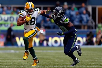 SEATTLE, WA - JANUARY 18: Randall Cobb #18 of the Green Bay Packers gives Jeremy Lane #20 of the Seattle Seahawks a stiff arm during the first quarter of the 2015 NFC Championship game at CenturyLink Field on January 18, 2015 in Seattle, Washington.  (Pho