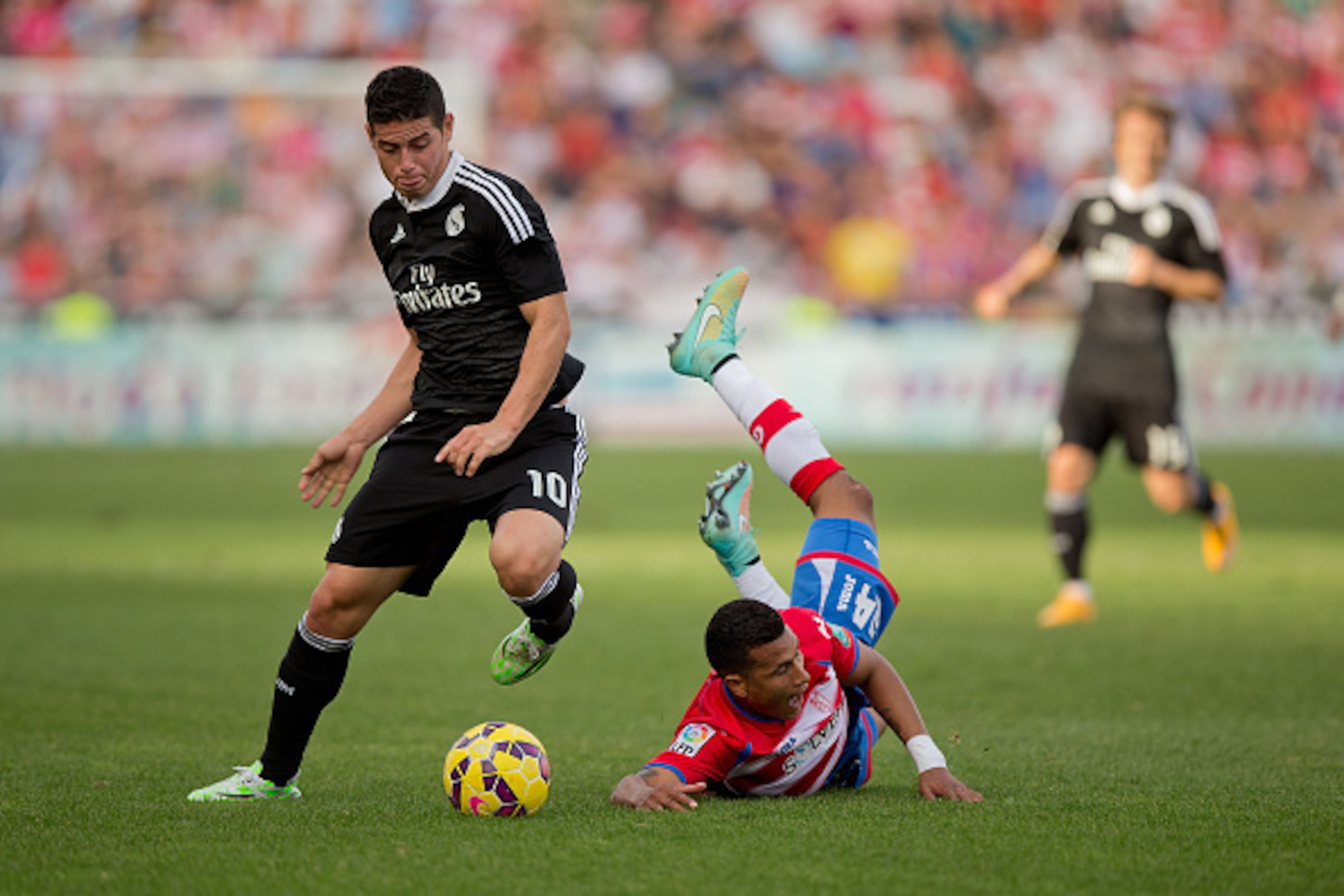 GRANADA, SPAIN - NOVEMBER 01:  James Rodriguez (L) of Real Madrid CF competes for the ball with Jeison Murillo (R) of Granada CF the La Liga match between Granada CF and Real Madrid CF at Nuevo Estadio de Los Carmenes on November 1, 2014 in Granada, Spain