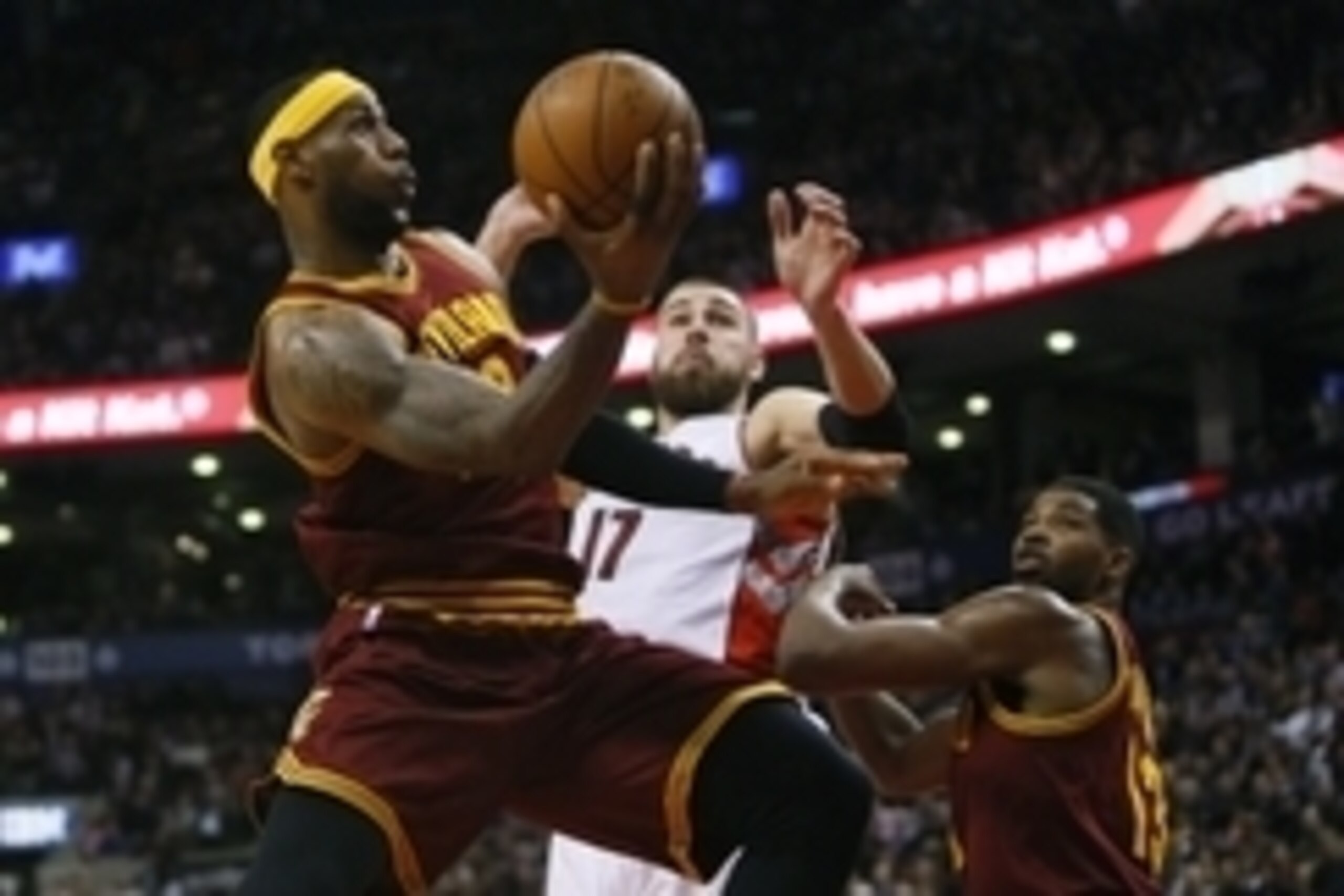 Mar 4, 2015; Toronto, Ontario, CAN; Cleveland Cavaliers forward LeBron James (23) goes up to make a basket as Toronto Raptors center Jonas Valanciunas (17) defends and Cleveland Cavaliers center Tristan Thompson (13) looks on at the Air Canada Centre. Cle