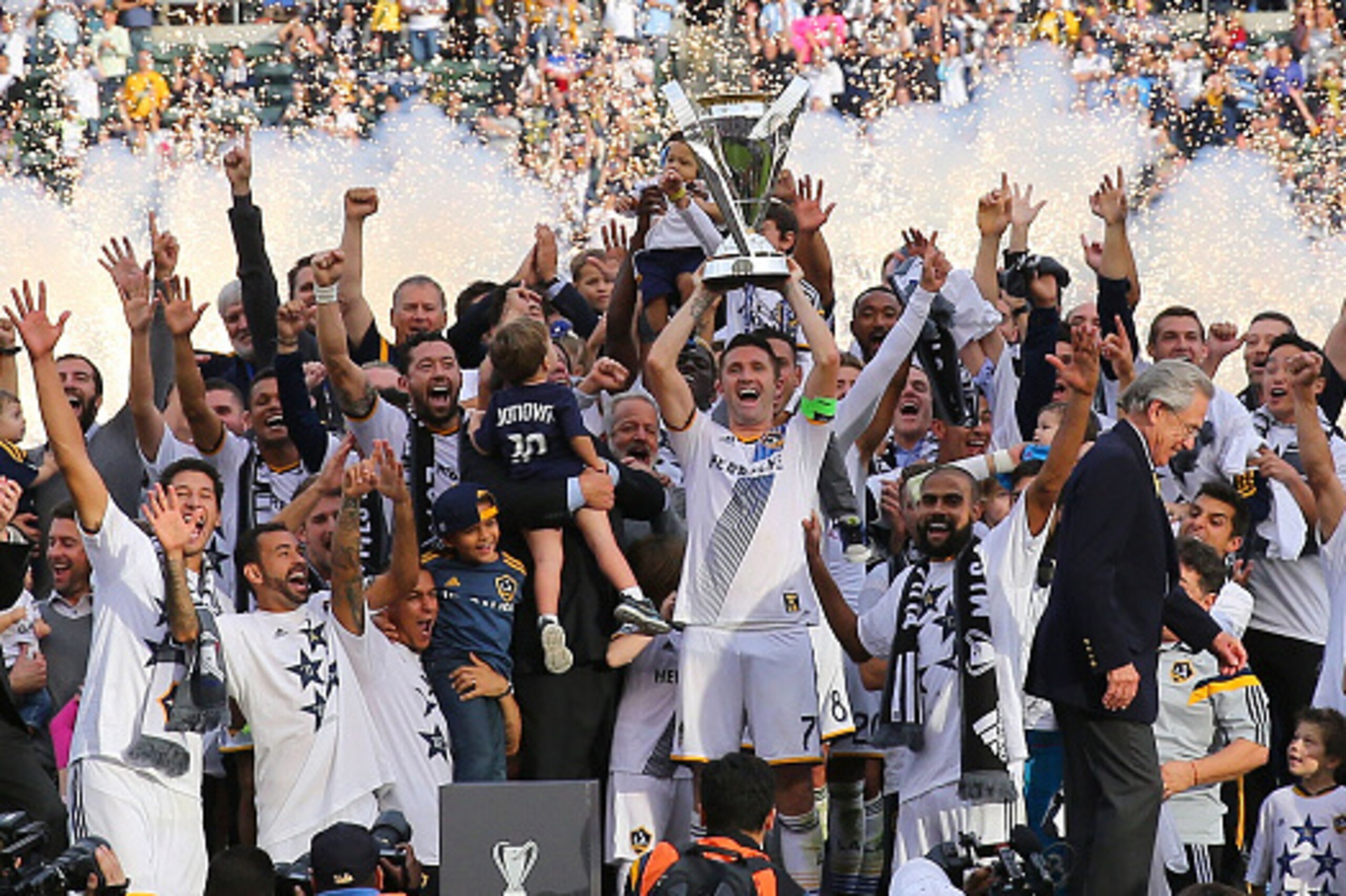 LOS ANGELES, CA - DECEMBER 07:  Captain Robbie Keane #7 of the Los Angeles Galaxy stands on the podium and hoists over his head the Philip F. Anschutz Trophy after the Galaxy defeated the New England Revolution 2-1 as team owner Philip Anschutz walks off 