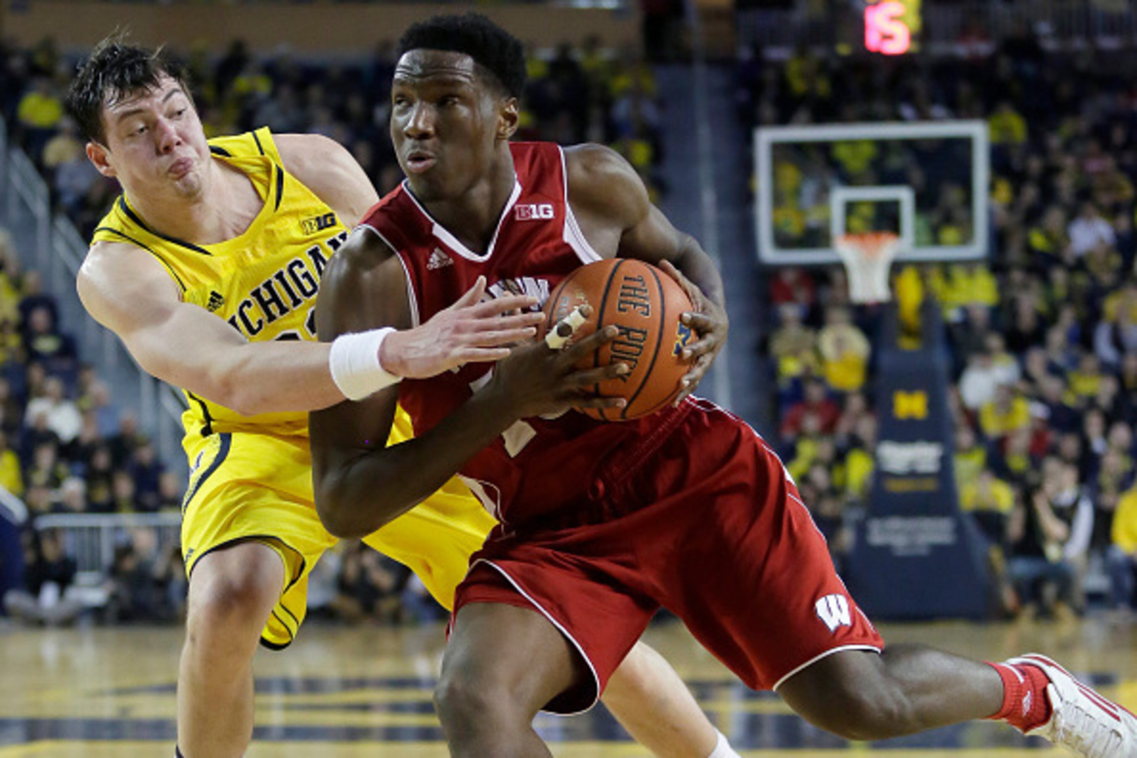 ANN ARBOR, MI - JANUARY 24:  Nigel Hayes #10 of the Wisconsin Badgers drives to the basket against Ricky Doyle #32 of the Michigan Wolverines during overtime play at a Big Ten game at Crisler Arena on January 24, 2015 in Ann Arbor, Michigan. Wisconsin def