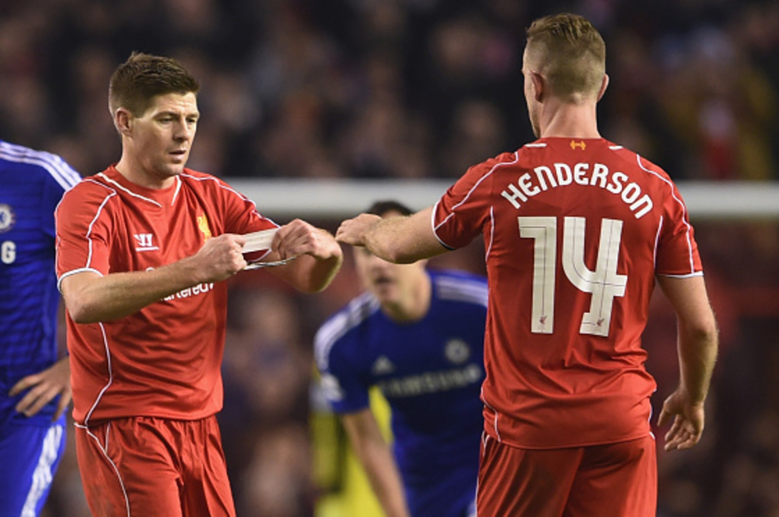 LIVERPOOL, ENGLAND - JANUARY 20:  Steven Gerrard of Liverpool hands the Captain's arm band over to Jordan Henderson of Liverpool during the Capital One Cup Semi-Final first leg match between Liverpool and Chelsea at Anfield on January 20, 2015 in Liverpoo