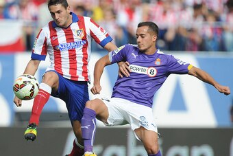 MADRID, SPAIN - OCTOBER 19:  Koke of Club Atletico de Madrid is tackled by Lucas Vazquez of RCD Espanyol during the La Liga match between Club Atletico de Madrid and RCD Espanyol at Vicente Calderon Stadium on October 19, 2014 in Madrid, Spain.  (Photo by
