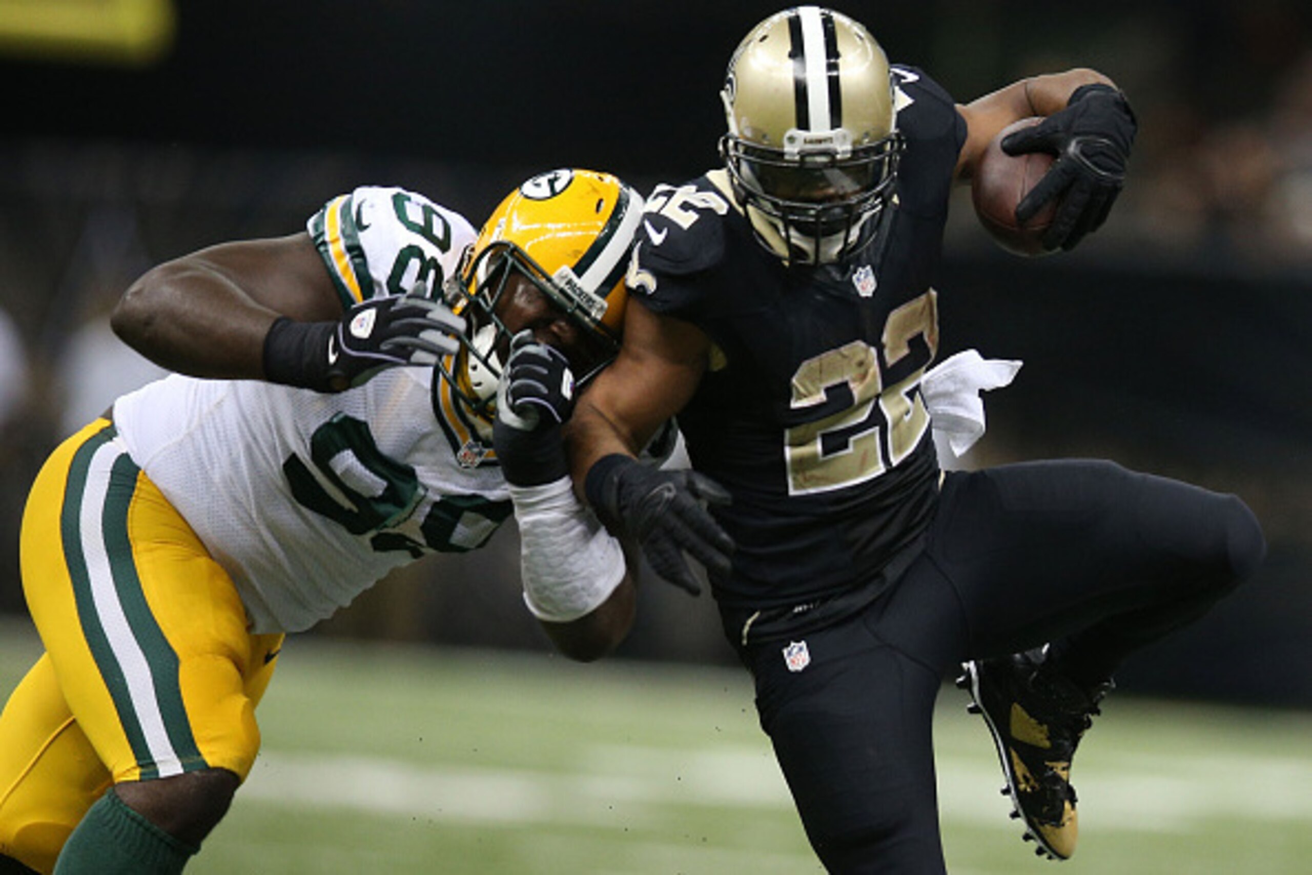 NEW ORLEANS, LA - OCTOBER 26:  Mark Ingram #22 of the New Orleans Saints runs the ball as Josh Boyd #93 of the Green Bay Packers defends during the second half at Mercedes-Benz Superdome on October 26, 2014 in New Orleans, Louisiana.  (Photo by Chris Gray