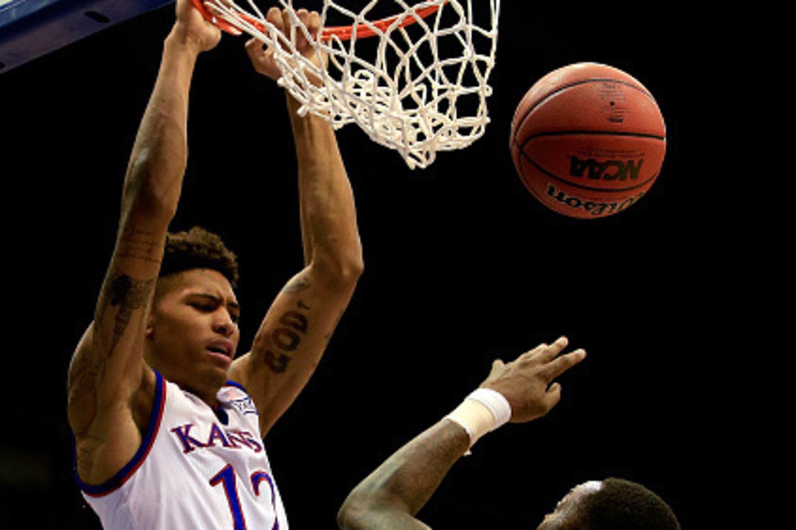 LAWRENCE, KS - MARCH 03:  Kelly Oubre Jr. #12 of the Kansas Jayhawks dunks over Elijah Macon #45 of the West Virginia Mountaineers during the game at Allen Fieldhouse on March 3, 2015 in Lawrence, Kansas.  (Photo by Jamie Squire/Getty Images)