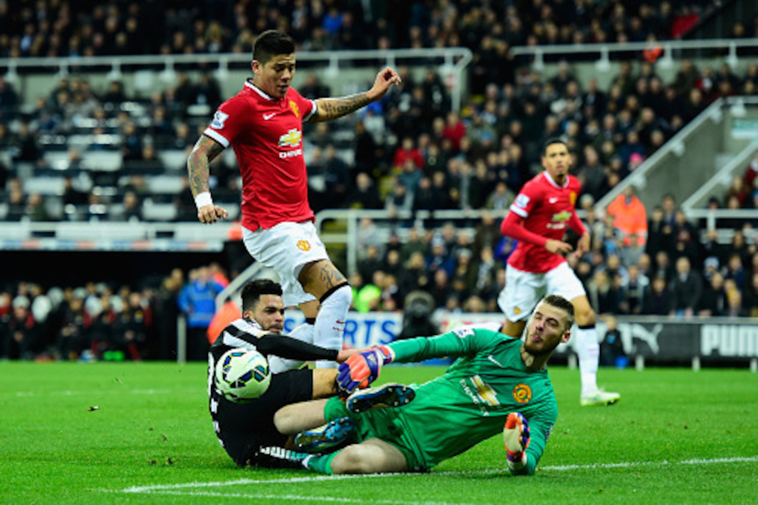 NEWCASTLE UPON TYNE, ENGLAND - MARCH 04:  Manchester United player Marcos Rojo and goalkeeper David De Gea combine to deny Emmanuel Riviere of Newcastle during the Barclays Premier League match between Newcastle United and Manchester United at St James' P