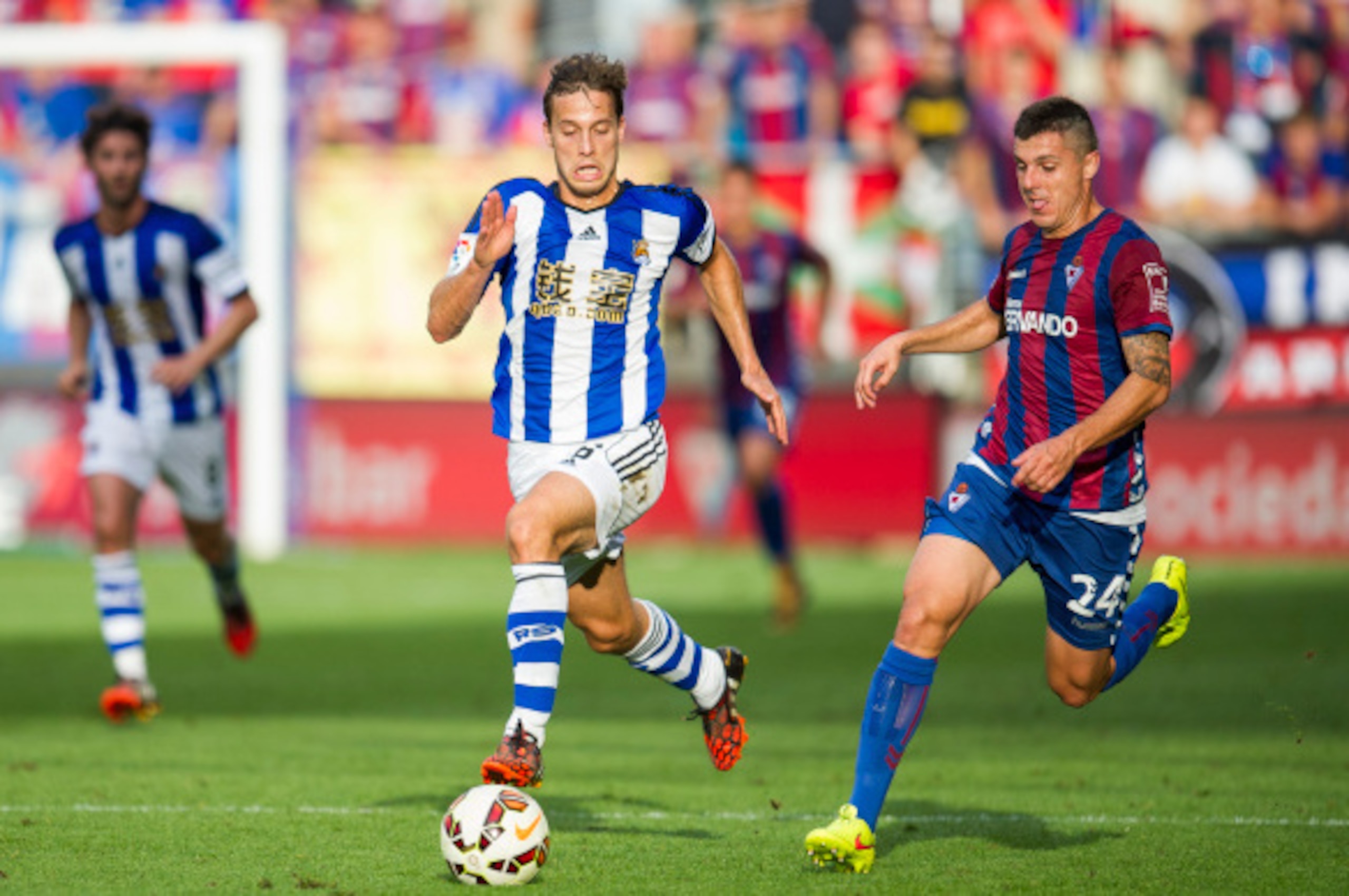 EIBAR, SPAIN - AUGUST 24:  Sergio Canales  of Real Sociedad duels for the ball withAbraham MInero of SD Eibar during the La Liga match between SD Eibar and Real Sociedad at Ipurua Municipal Stadium on August 24, 2014 in Eibar, Spain.  (Photo by Juan Manue