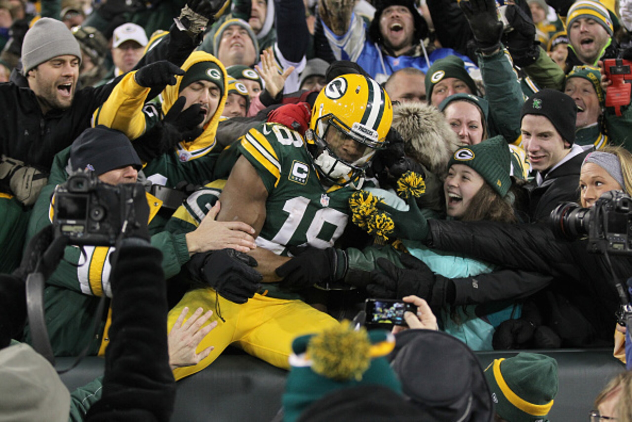 GREEN BAY, WI - DECEMBER 28:  Wide receiver Randall Cobb #18 of the Green Bay Packers leaps into the crowd after scoring in the third quarter for his second touchdown against the Detroit Lions during the NFL game at Lambeau Field on December 28, 2014 in G