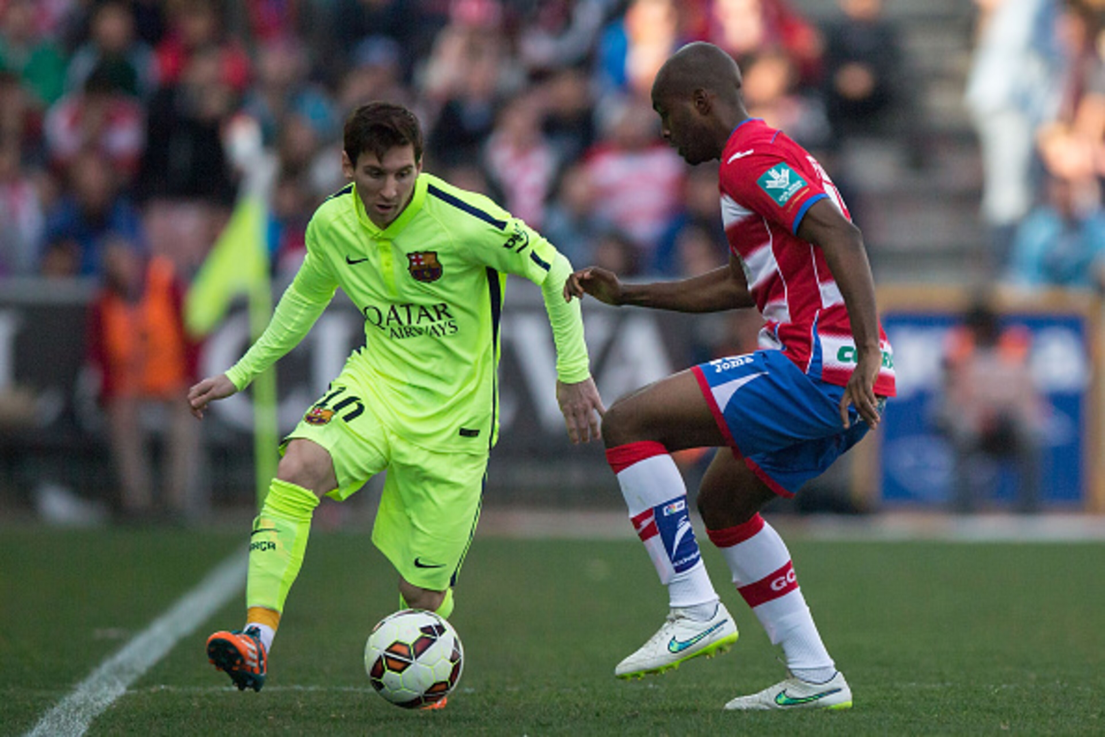 GRANADA, SPAIN - FEBRUARY 28: Lionel Messi (L) of FC Barcelona competes for the ball with Dimitri Foulquier (R) of Granada CF during the La Liga match between Granada CF and FC Barcelona at Nuevo Estadio de los Carmenes on February 28, 2015 in Granada, Sp
