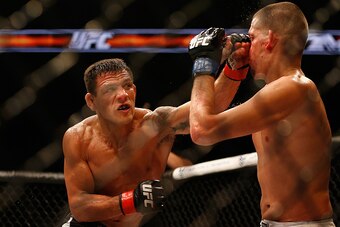 PHOENIX, AZ - DECEMBER 13:  Rafael dos Anjos (L) punches Nate Diaz in their heavyweight bout during the UFC Fight Night event at the at U.S. Airways Center on December 13, 2014 in Phoenix, Arizona.  (Photo by Christian Petersen/Getty Images)