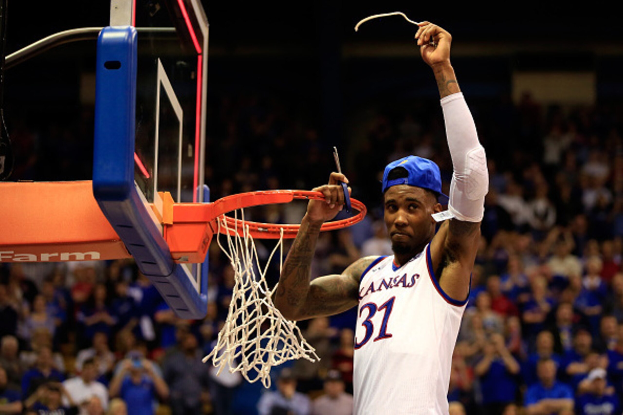 LAWRENCE, KS - MARCH 03:  Jamari Traylor #31 of the Kansas Jayhawks cuts down the net after the Jayhawks defeated the West Virginia Mountaineers 76-69 in overtime to win the game and clinch their eleventh straight Big IX Championship title at Allen Fieldh