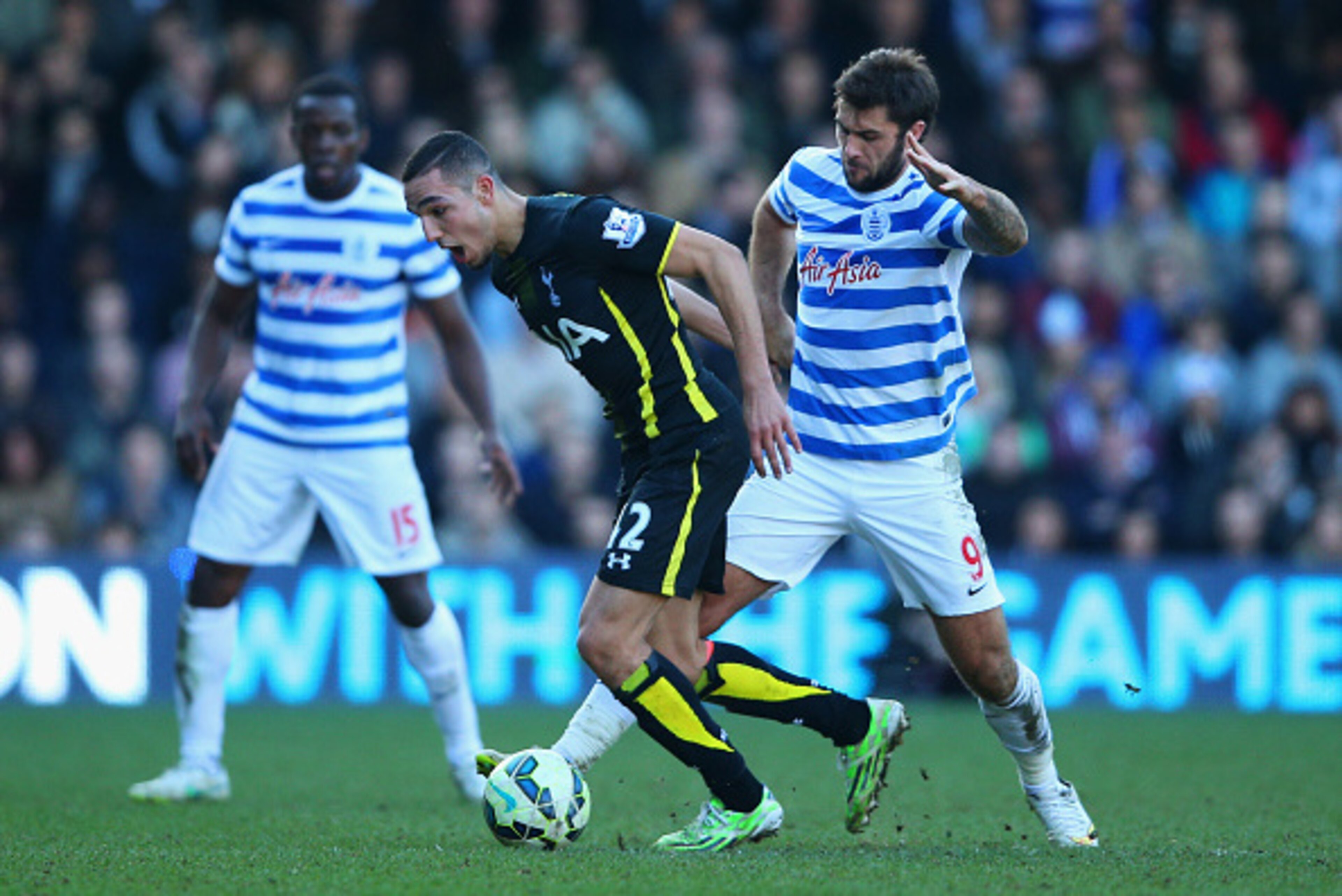 LONDON, ENGLAND - MARCH 07:  Nabil Bentaleb of Spurs evades Charlie Austin of QPR during the Barclays Premier League match between Queens Park Rangers and Tottenham Hotspur at Loftus Road on March 7, 2015 in London, England.  (Photo by Paul Gilham/Getty I