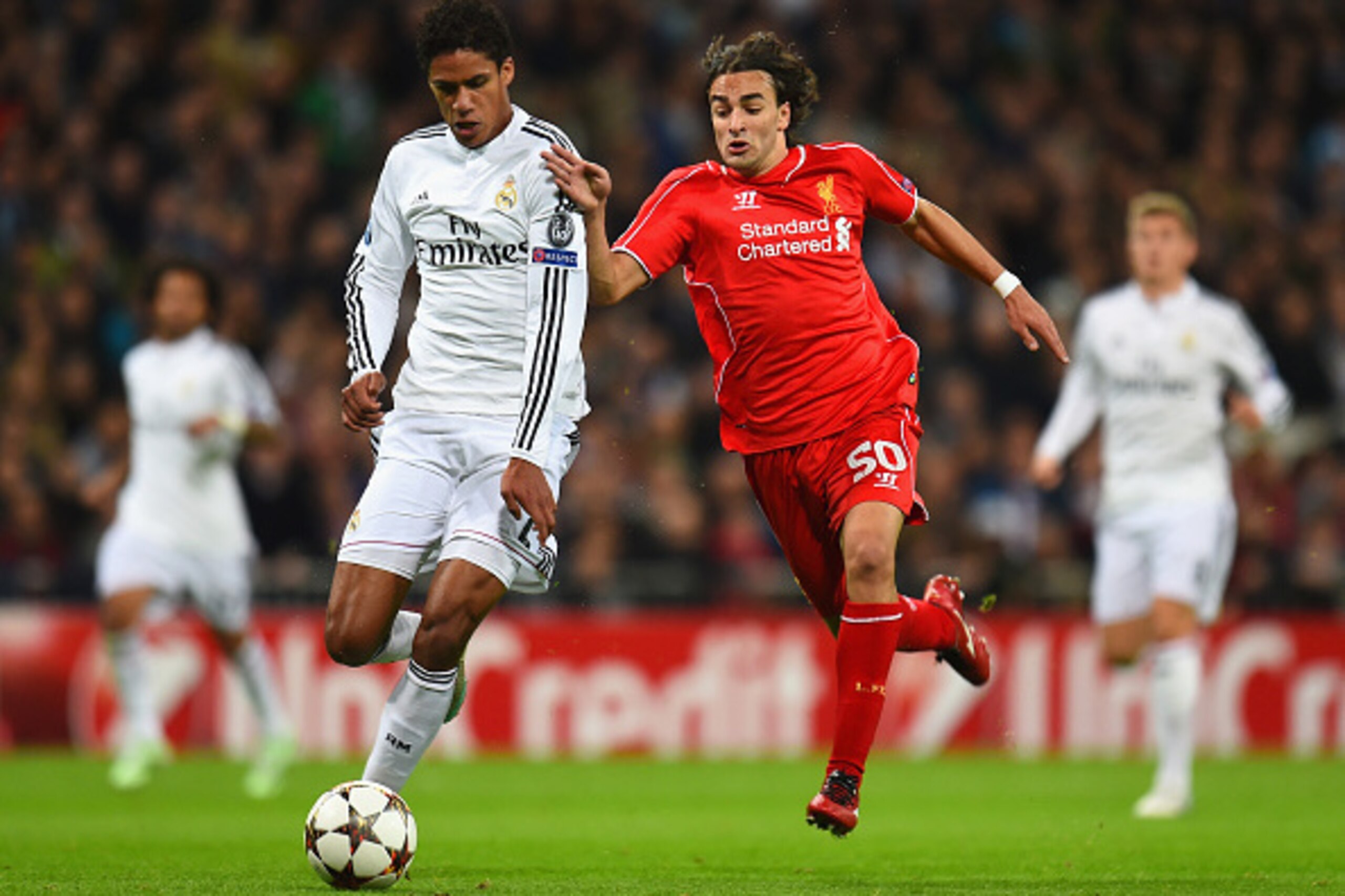 MADRID, SPAIN - NOVEMBER 04: Raphael Varane of Real Madrid CF and Lazar Markovic of Liverpool compete for the ball during the UEFA Champions League Group B match between Real Madrid CF and Liverpool FC at Estadio Santiago Bernabeu on November 4, 2014 in M