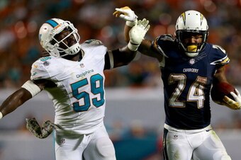 MIAMI GARDENS, FL - NOVEMBER 17:  Ryan Mathews #24 of the San Diego Chargers tries to get away from Dannell Ellerbe #59 of the Miami Dolphins during their game at Sun Life Stadium on November 17, 2013 in Miami Gardens, Florida.  (Photo by Streeter Lecka/G