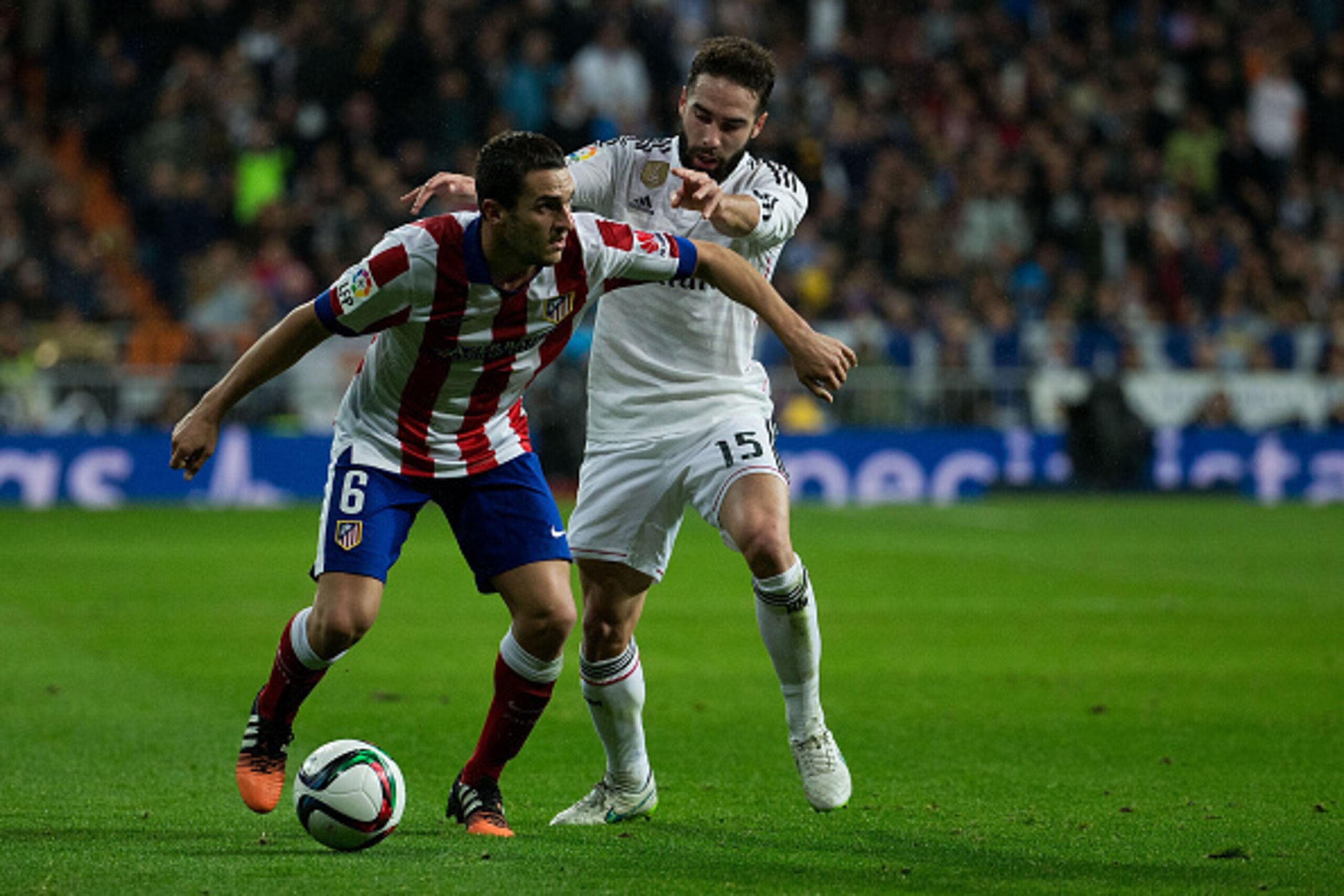 MADRID, SPAIN - JANUARY 15: Koke (L) of Atletico de Madrid competes for the ball with Daniel Carvajal (R) of Real Madrid CF during the Copa del Rey Round of 16  second leg match between Real Madrid CF and Club Atletico de Madrid at Estadio Santiago Bernab