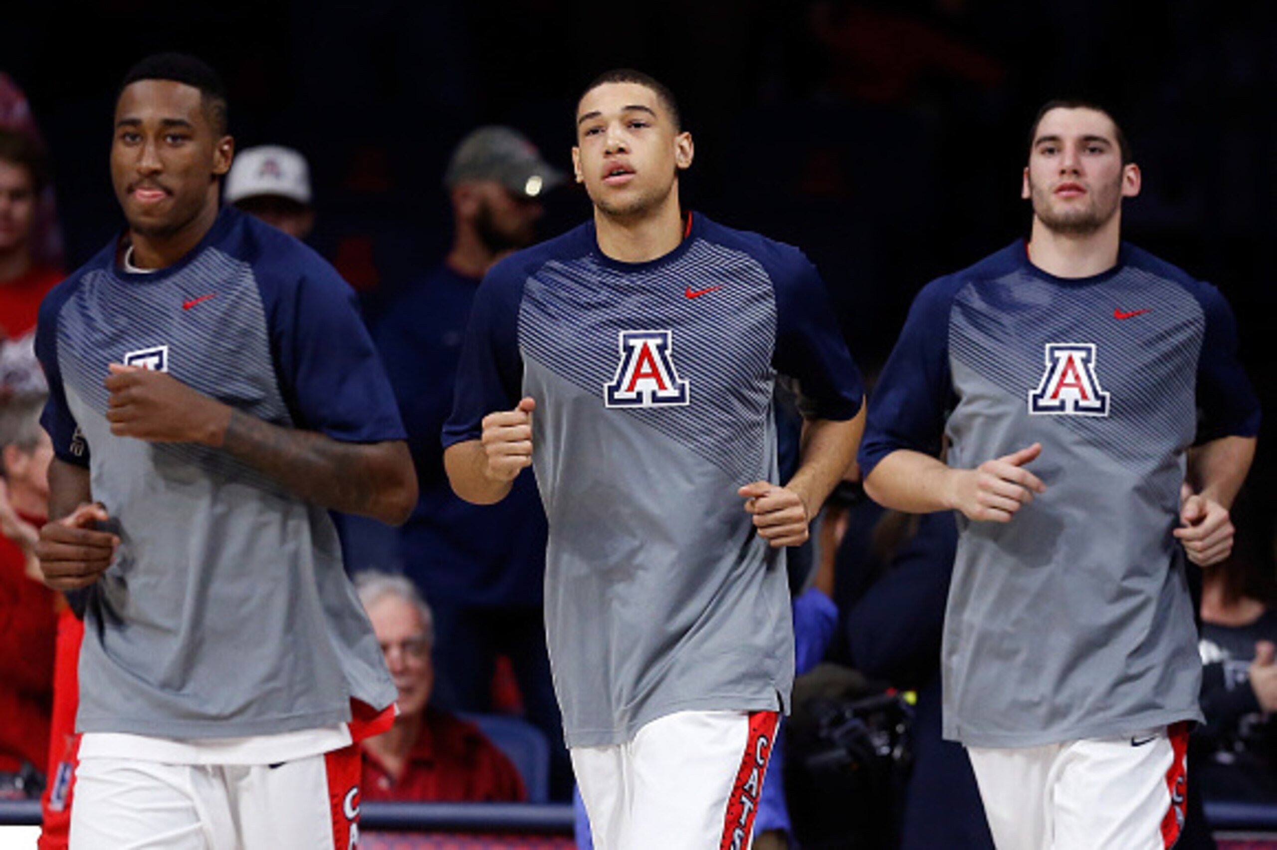 TUCSON, AZ - DECEMBER 09:  (L-R) Rondae Hollis-Jefferson #23, Brandon Ashley #21 and Matt Korcheck #31 of the Arizona Wildcats run out onto the court before the college basketball game against the Utah Valley Wolverines at McKale Center on December 9, 201