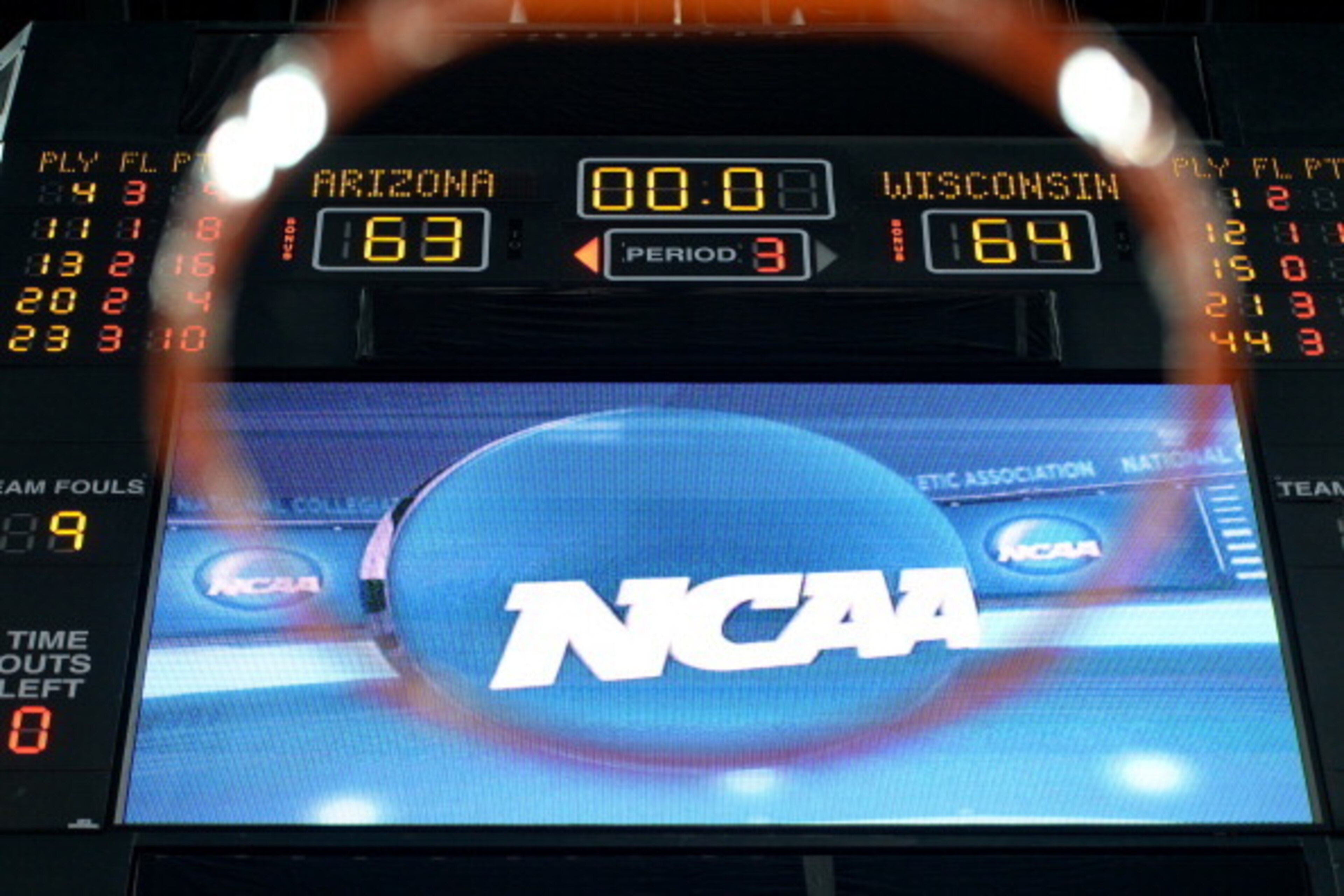 ANAHEIM, CA - MARCH 29: The scoreboard is seen through the rim as the Wisconsin Badgers defeat the Arizona Wildcats 64-63 in overtime during the West Regional Final of the 2014 NCAA Men's Basketball Tournament at the Honda Center on March 29, 2014 in Ana ANAHEIM, CA - MARCH 29: The scoreboard is seen through the rim as the Wisconsin Badgers defeat the Arizona Wildcats 64-63 in overtime during the West Regional Final of the 2014 NCAA Men's Basketball Tournament at the Honda Center on March 29, 2014 in Ana