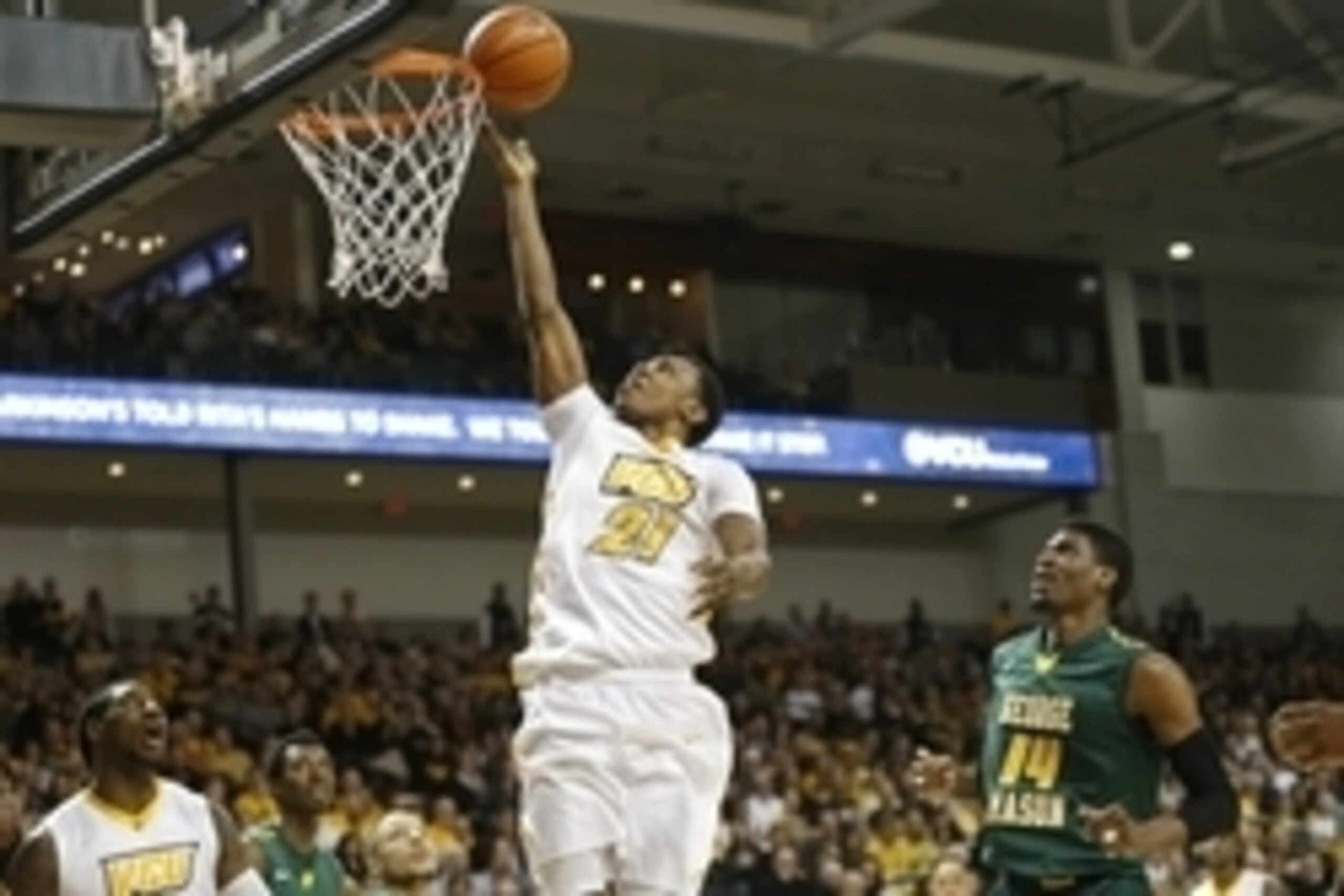 Mar 7, 2015; Richmond, VA, USA; Virginia Commonwealth Rams guard/forward Treveon Graham (21) shoots the ball as George Mason Patriots center Shevon Thompson (14) looks on in the first half at Stuart Siegel Center. Mandatory Credit: Geoff Burke-USA TODAY S