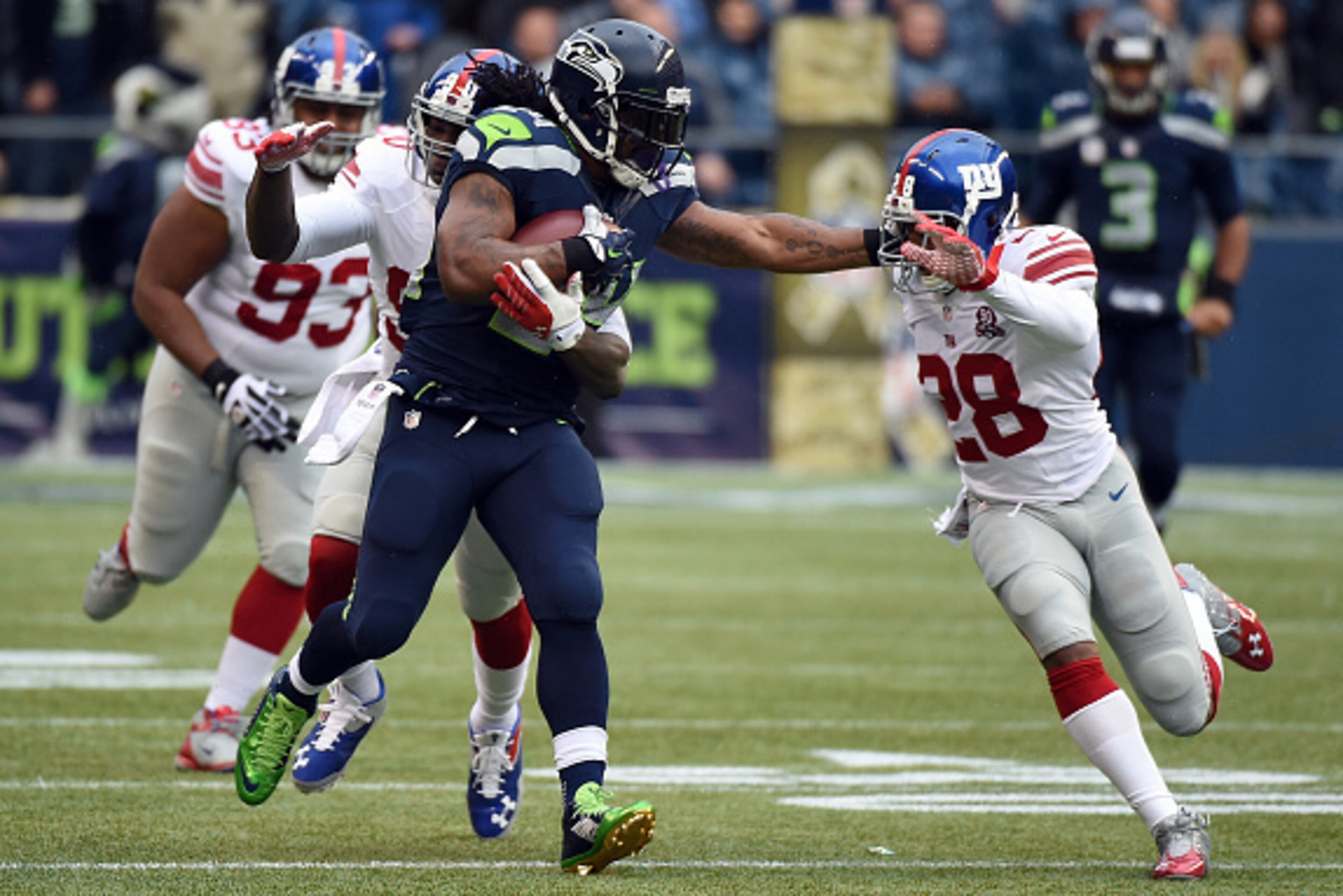 SEATTLE, WA - NOVEMBER 09: Running back Marshawn Lynch #24 of the Seattle Seahawks gives cornerback Jayron Hosley #28 of the New York Giants a stiff arm during the first quarter of the game at CenturyLink Field on November 9, 2014 in Seattle, Washington. 