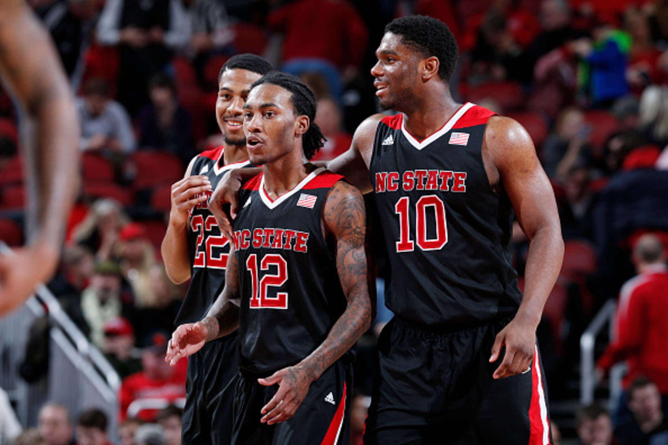LOUISVILLE, KY - FEBRUARY 14: Anthony Barber #12, Lennard Freeman #10 and Ralston Turner #22 of the North Carolina State Wolfpack celebrate in the closing seconds of the game against the Louisville Cardinals at KFC Yum! Center on February 14, 2015 in Loui
