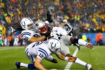 FOXBORO, MA - JANUARY 18:  Darrelle Revis #24 of the New England Patriots is tackled by  Andrew Luck #12 of the Indianapolis Colts after intercepting Luck's pass in the third quarter of the 2015 AFC Championship Game at Gillette Stadium on January 18, 201