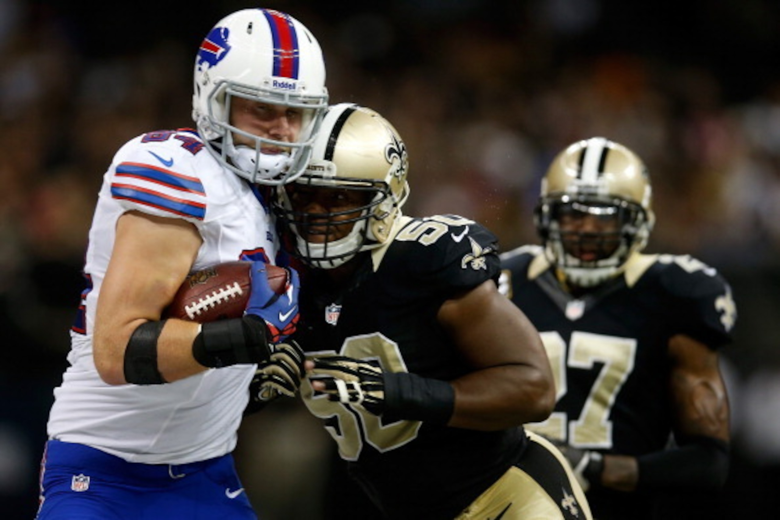 NEW ORLEANS, LA - OCTOBER 27:  Scott Chandler #84 of the Buffalo Bills is tackled by  Curtis Lofton #50 of the New Orleans Saints at Mercedes-Benz Superdome on October 27, 2013 in New Orleans, Louisiana.  (Photo by Chris Graythen/Getty Images)