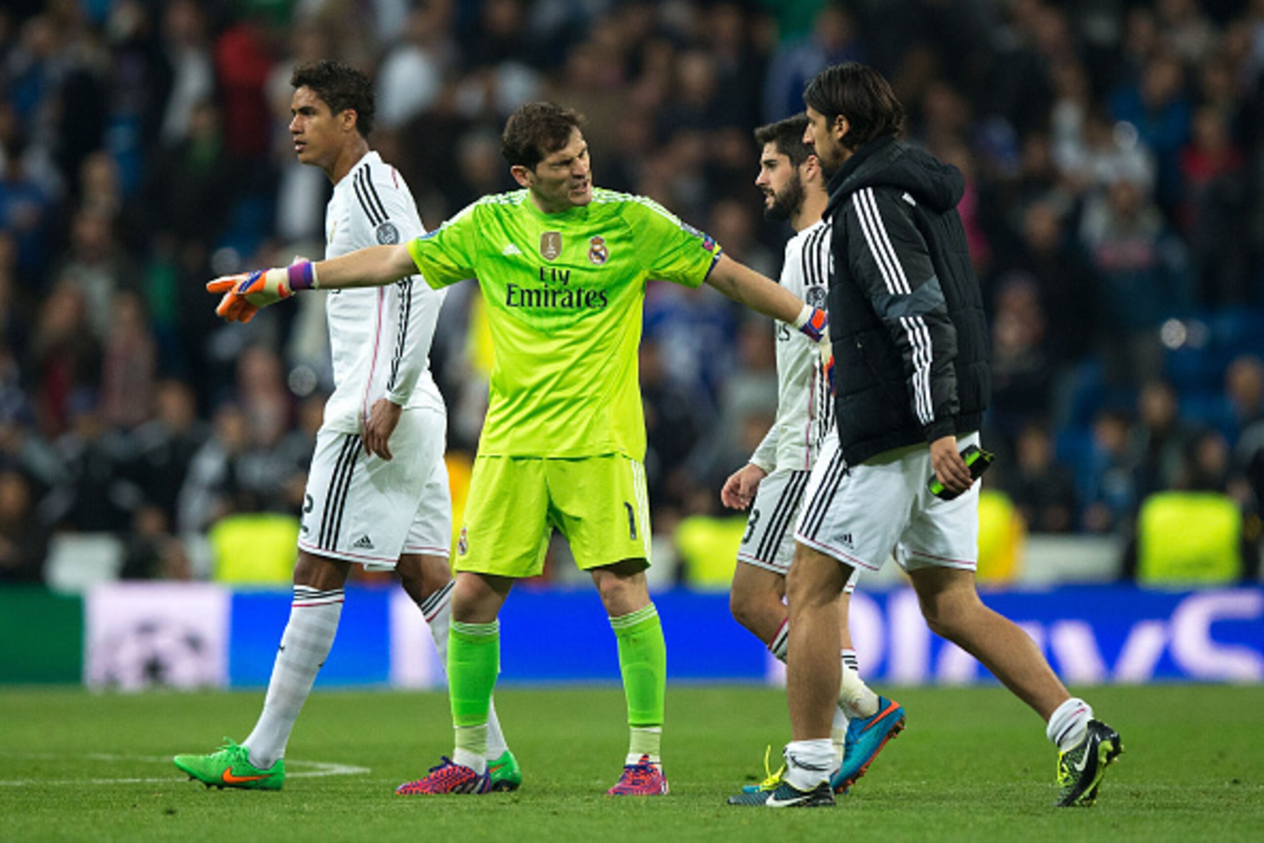 MADRID, SPAIN - MARCH 10:  goalkeeper Iker Casillas (2ndL) of Real Madrid CF holds his teammates Francisco Roman Alarcon alias Isco (2ndR) and Sami Khedira (R) in order to greets the audience close to Raphael Varane (L) after loosing the UEFA Champions Le