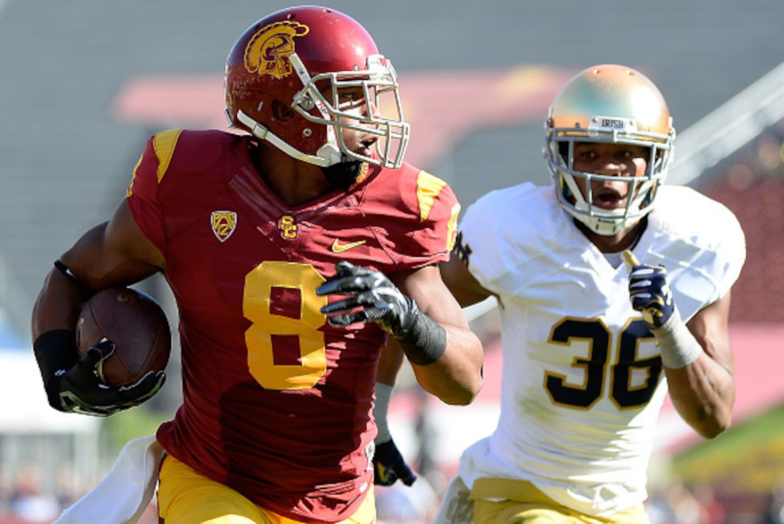 LOS ANGELES, CA - NOVEMBER 29:  George Farmer #8 of the USC Trojans runs for a touchdown after his catch in front of Cole Luke #36 of the Notre Dame Fighting Irish during the first quarter at Los Angeles Memorial Coliseum on November 29, 2014 in Los Angel