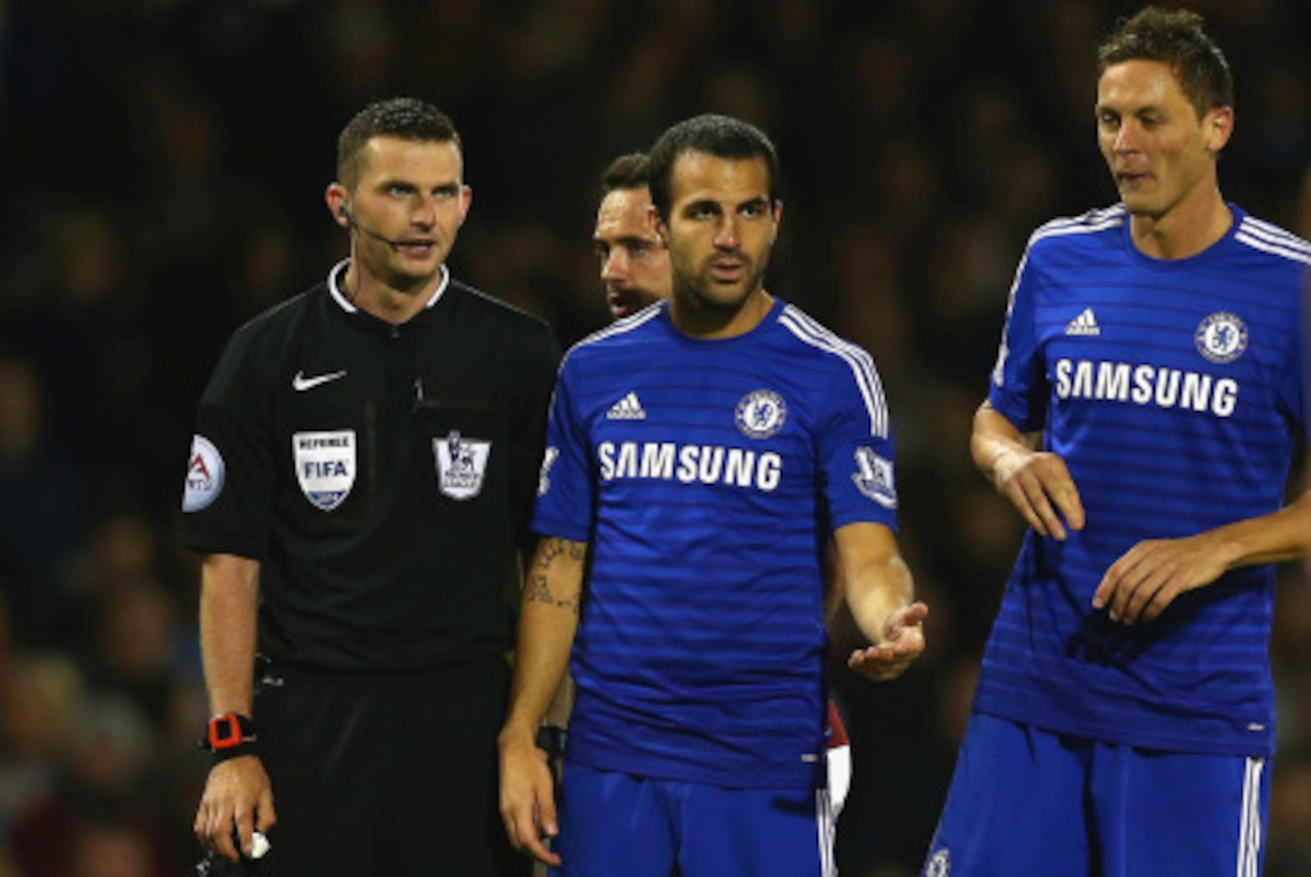 BURNLEY, ENGLAND - AUGUST 18:   Referee Michael Oliver speaks to Cesc Fabregas and Nemanja Matic of Chelsea during the Barclays Premier League match between Burnley and Chelsea at Turf Moor on August 18, 2014 in Burnley, England.  (Photo by Clive Brunskil