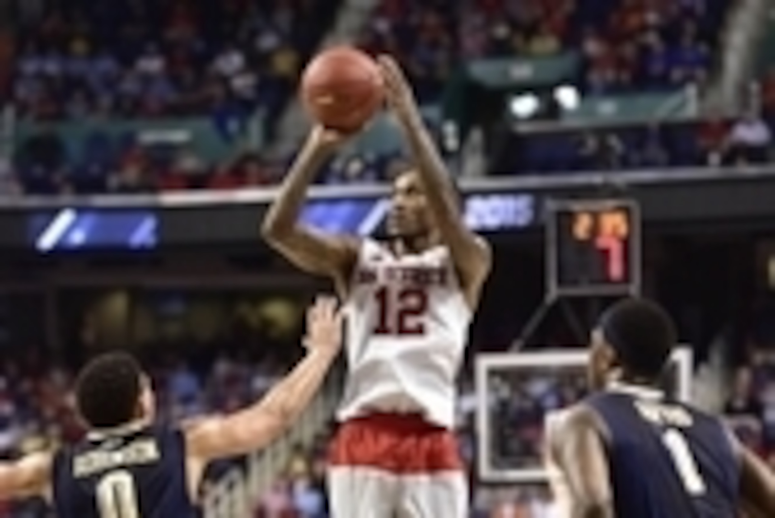 Mar 11, 2015; Greensboro, NC, USA; North Carolina State Wolfpack guard Anthony Barber (12) shoots as Pittsburgh Panthers guard James Robinson (0) and forward Jamel Artis (1) defend in the first half in the second round at Greensboro Coliseum. Mandatory Cr