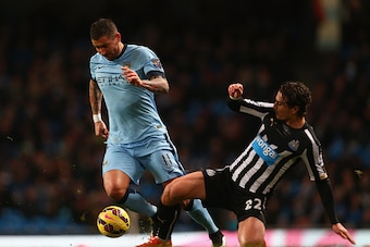 MANCHESTER, ENGLAND - FEBRUARY 21:  Daryl Janmaat of Newcastle United tackles Aleksandar Kolarov of Manchester City during the Barclays Premier League match between Manchester City and Newcastle United at Etihad Stadium on February 21, 2015 in Manchester,