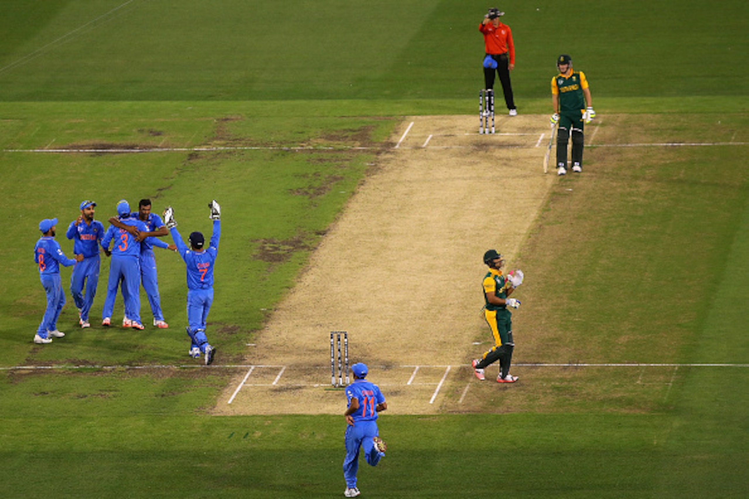 MELBOURNE, AUSTRALIA - FEBRUARY 22:  Ravichandran Ashwin of India is congratulated by team mates after taking the wicket of JP Duminy of South Africa during the 2015 ICC Cricket World Cup match between South Africa and India at Melbourne Cricket Ground on