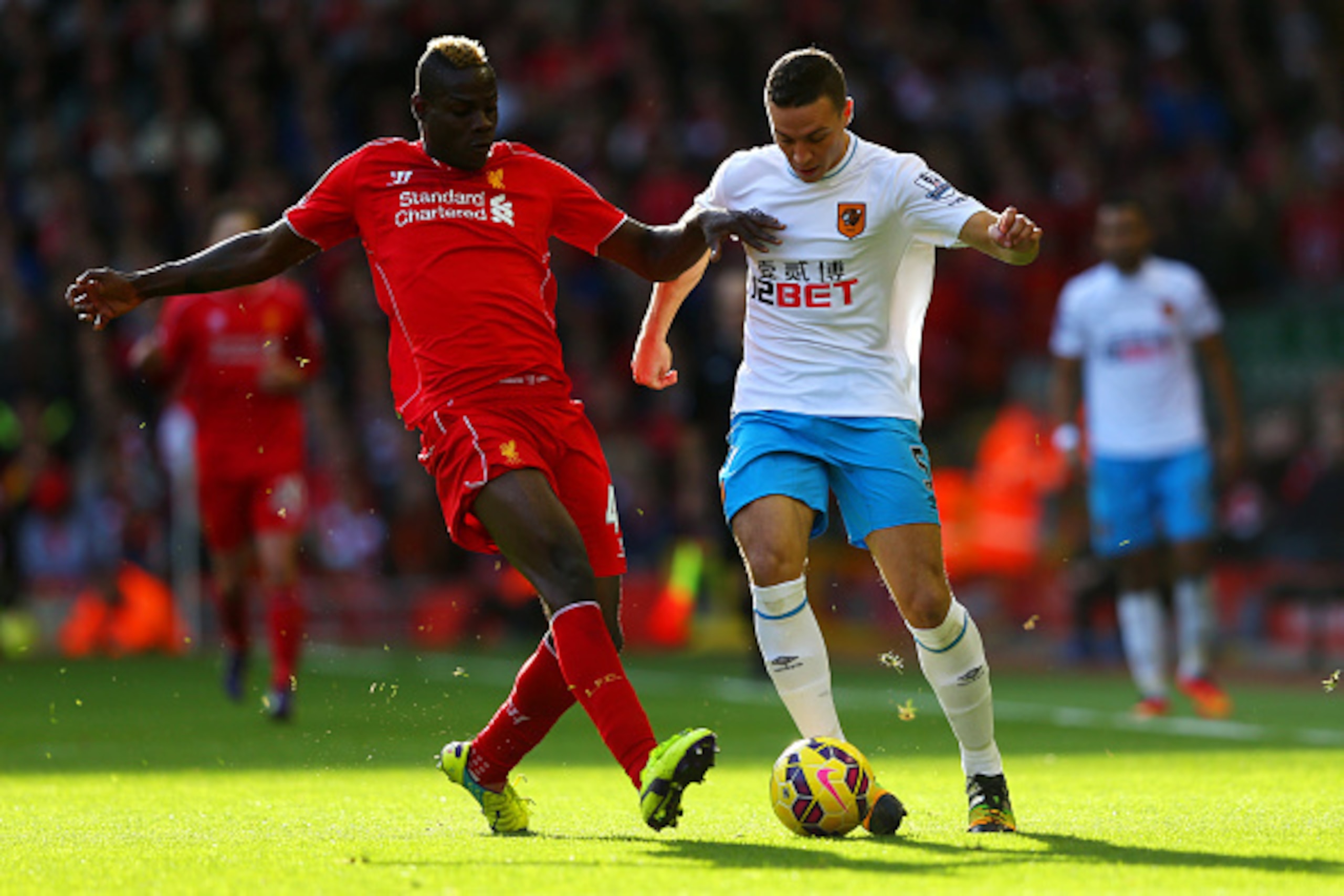 LIVERPOOL, ENGLAND - OCTOBER 25:  Mario Balotelli of Liverpool is challenged by James Chester of Hull City during the Barclays Premier League match between Liverpool and Hull City at Anfield on October 25, 2014 in Liverpool, England.  (Photo by Alex Lives