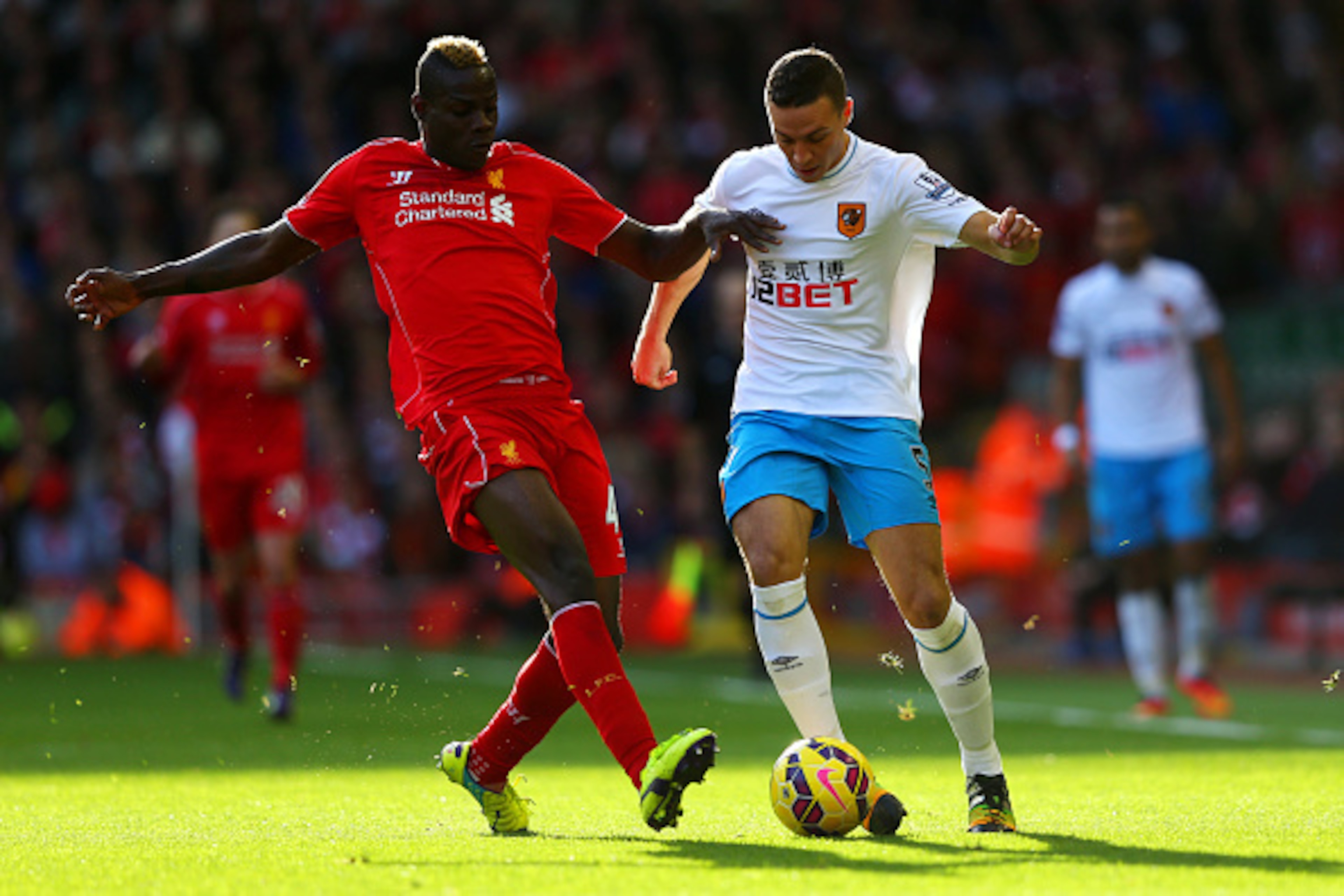 LIVERPOOL, ENGLAND - OCTOBER 25:  Mario Balotelli of Liverpool is challenged by James Chester of Hull City during the Barclays Premier League match between Liverpool and Hull City at Anfield on October 25, 2014 in Liverpool, England.  (Photo by Alex Lives