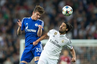 MADRID, SPAIN - MARCH 10: Roman Neustadter of FC Schalke 04 wins the header before Sami Khedira of Real Madrid CF during the UEFA Champions League round of 16 second leg match between Real Madrid CF and FC Schalke 04 at Estadio Santiago Bernabeu on March 