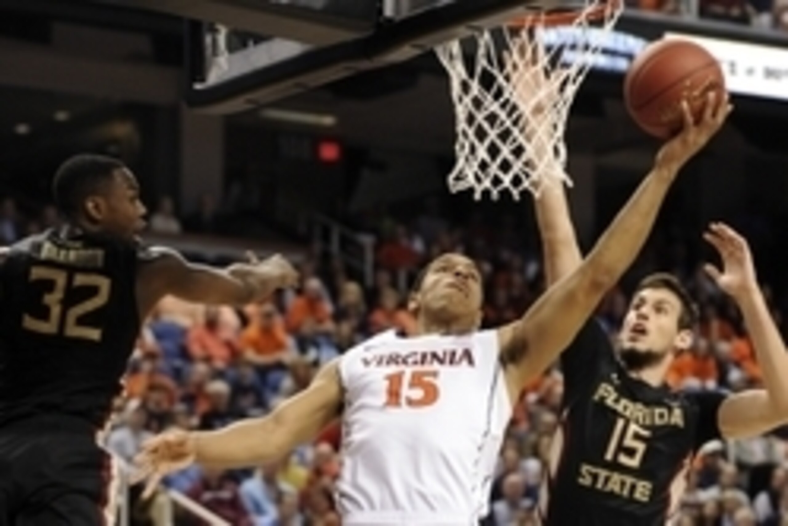 Mar 12, 2015; Greensboro, NC, USA; Virginia Cavaliers guard Malcolm Brogdon (15) shoots between Florida State Seminoles guard Montay Brandon (32) and  center Boris Bojanovsky (15) in the first half during the quarterfinals of the ACC Tournament at Greensb