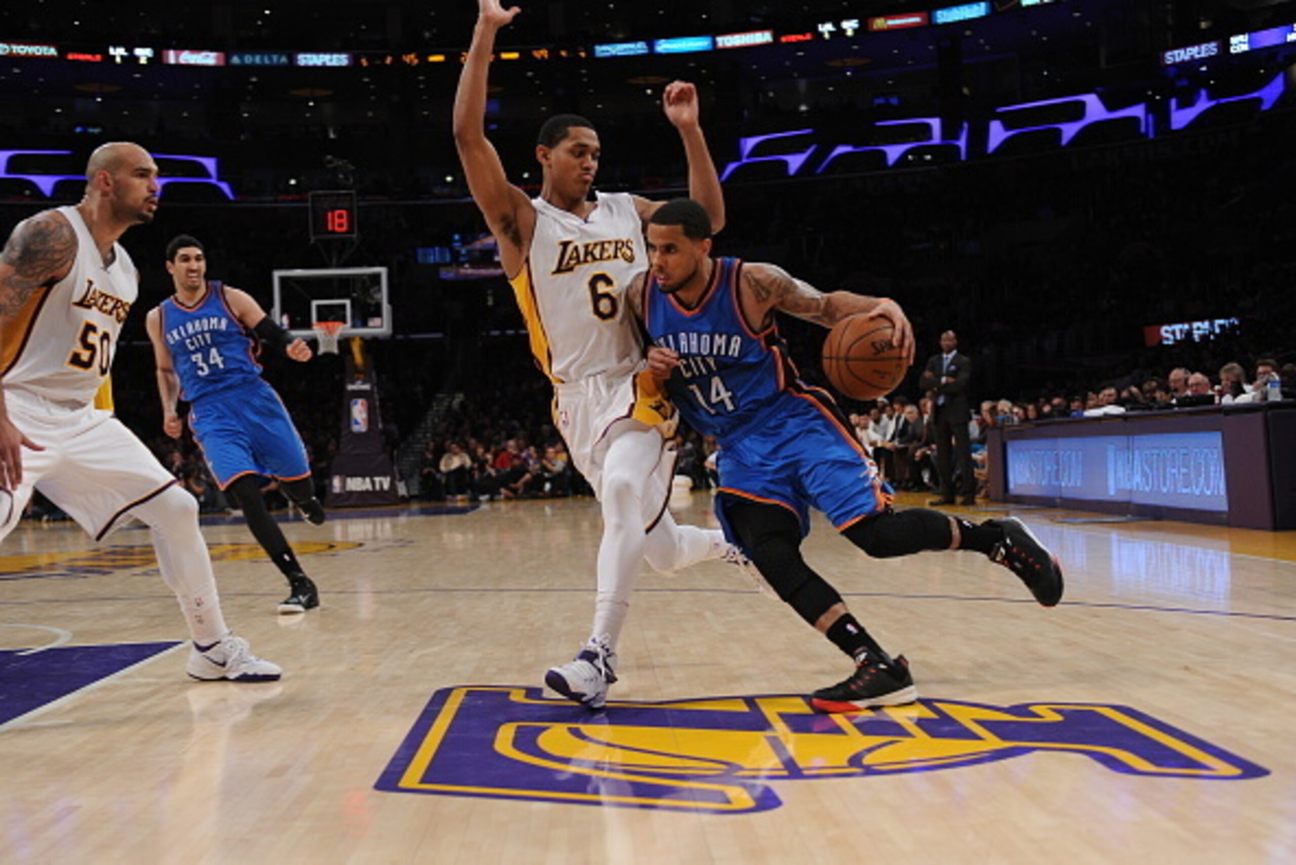 LOS ANGELES, CA - MARCH 1:  D.J. Augustin #14 of the Oklahoma City Thunder drives to the basket against Jordan Clarkson #6 of the Los Angeles Lakers on March 1, 2015 at Staples Center in Los Angeles, California. NOTE TO USER: User expressly acknowledges a