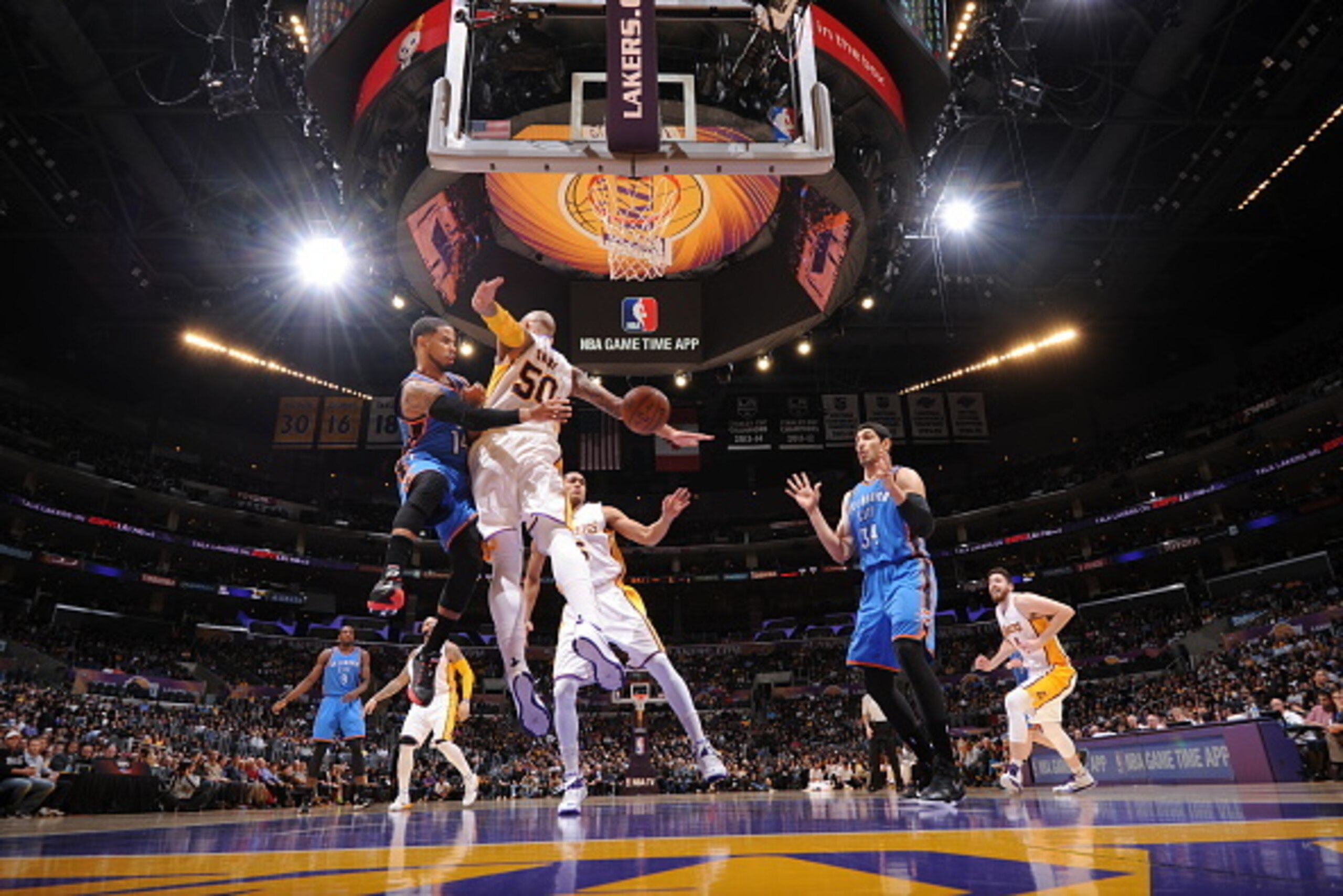 LOS ANGELES, CA - MARCH 1:  D.J. Augustin #14 of the Oklahoma City Thunder passes the ball to Enes Kanter #34 against Robert Sacre #50 of the Los Angeles Lakers on March 1, 2015 at Staples Center in Los Angeles, California. NOTE TO USER: User expressly ac