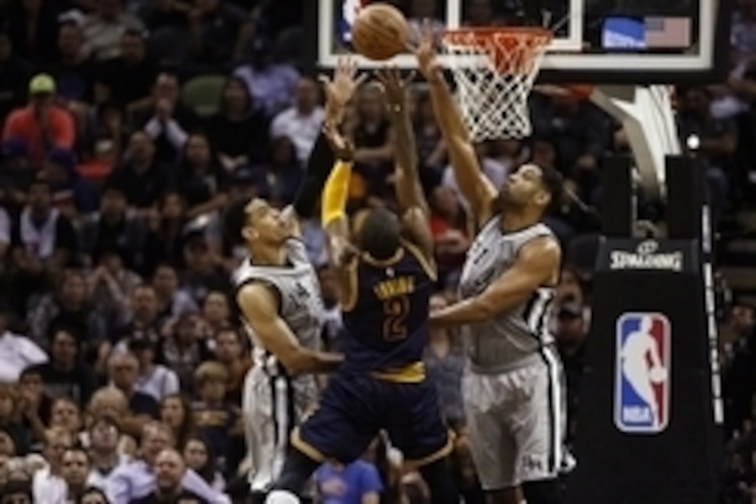 Mar 12, 2015; San Antonio, TX, USA; Cleveland Cavaliers guard Kyrie Irving (2) shoots the ball over San Antonio Spurs shooting guard Danny Green (14) and power forward Tim Duncan (21) during the second half at AT&T Center. Mandatory Credit: Soobum Im-USA 