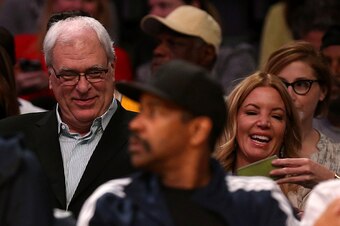 LOS ANGELES, CA - MARCH 12:  Phil Jackson, president of the New York Knicks, sits with Jeanie Buss, part-owner and president the Los Angeles Lakers, at Staples Center on March 12, 2015 in Los Angeles, California. Actor Denzel Washington is in the foregrou