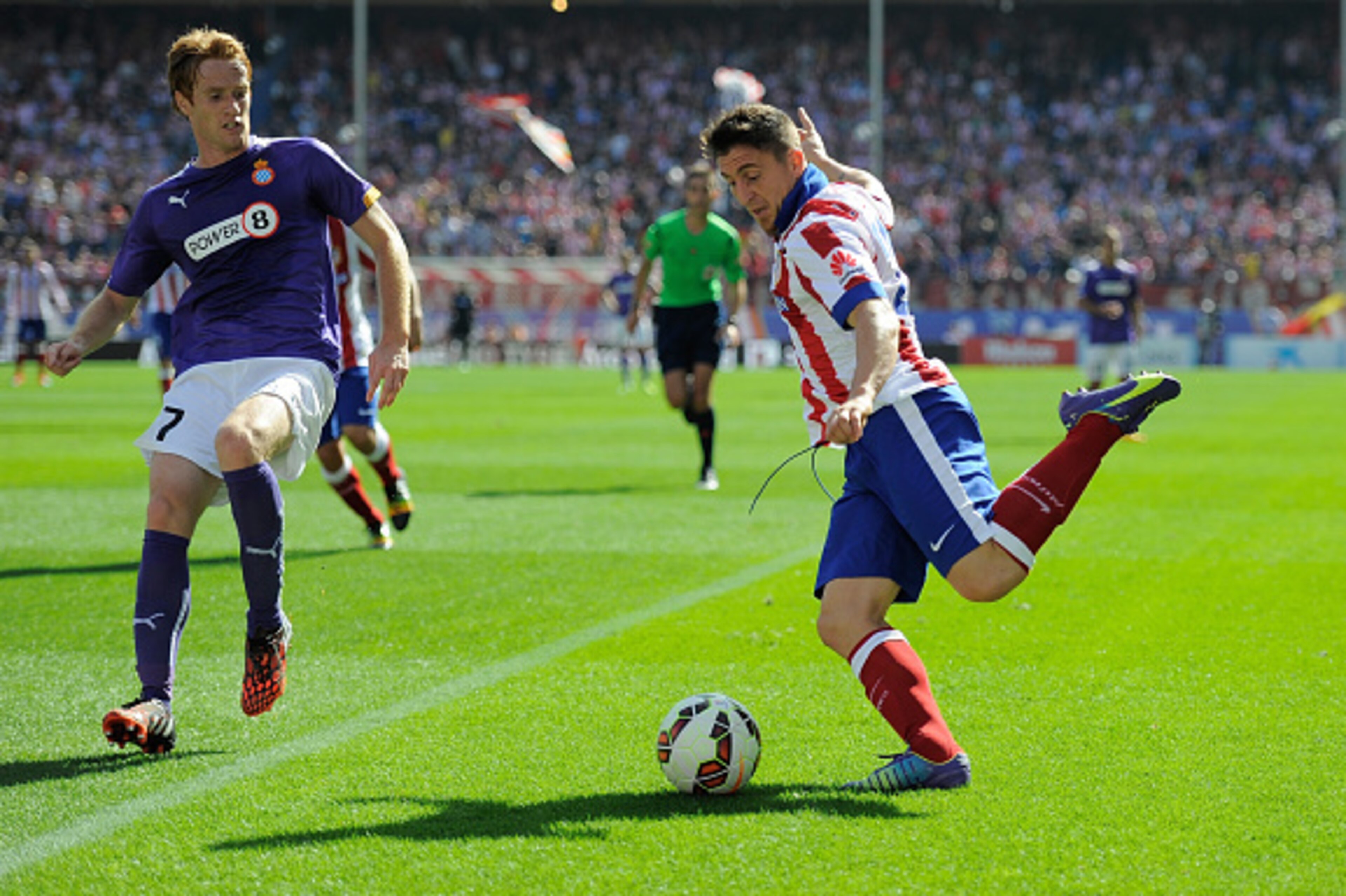 MADRID, SPAIN - OCTOBER 19:  Koke of Club Atletico de Madrid crosses the ball beside Lucas Vazquez of RCD Espanyol during the La Liga match between Club Atletico de Madrid and RCD Espanyol at Vicente Calderon Stadium on October 19, 2014 in Madrid, Spain. 