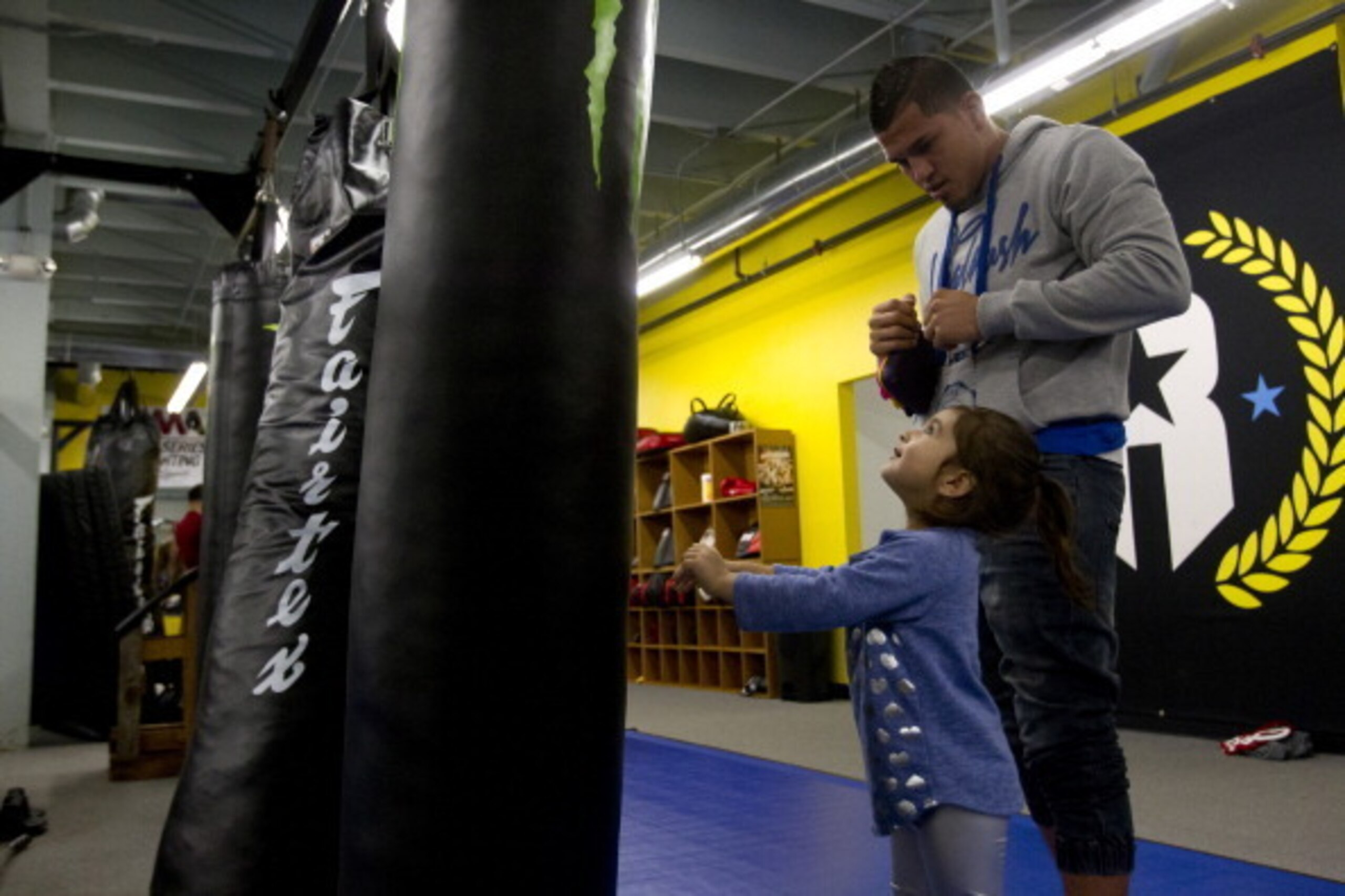 MILWAUKEE, WI - JANUARY 16: Anthony Pettis and daughter Aria Pettis hit a heavy bag before interviewing for Media Day at Roufusport Mixed Martial Arts Academy on January 16, 2014 in Milwaukee, Wisconsin. (Photo by Mike McGinnis/Getty Images)