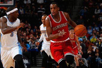 DENVER, CO - MARCH 03:  Khris Middleton #22 of the Milwaukee Bucks conrols the ball against Ty Lawson #3 of the Denver Nuggets at Pepsi Center on March 3, 2015 in Denver, Colorado. The Nuggets defeated the Bucks 106-95. NOTE TO USER: User expressly acknow