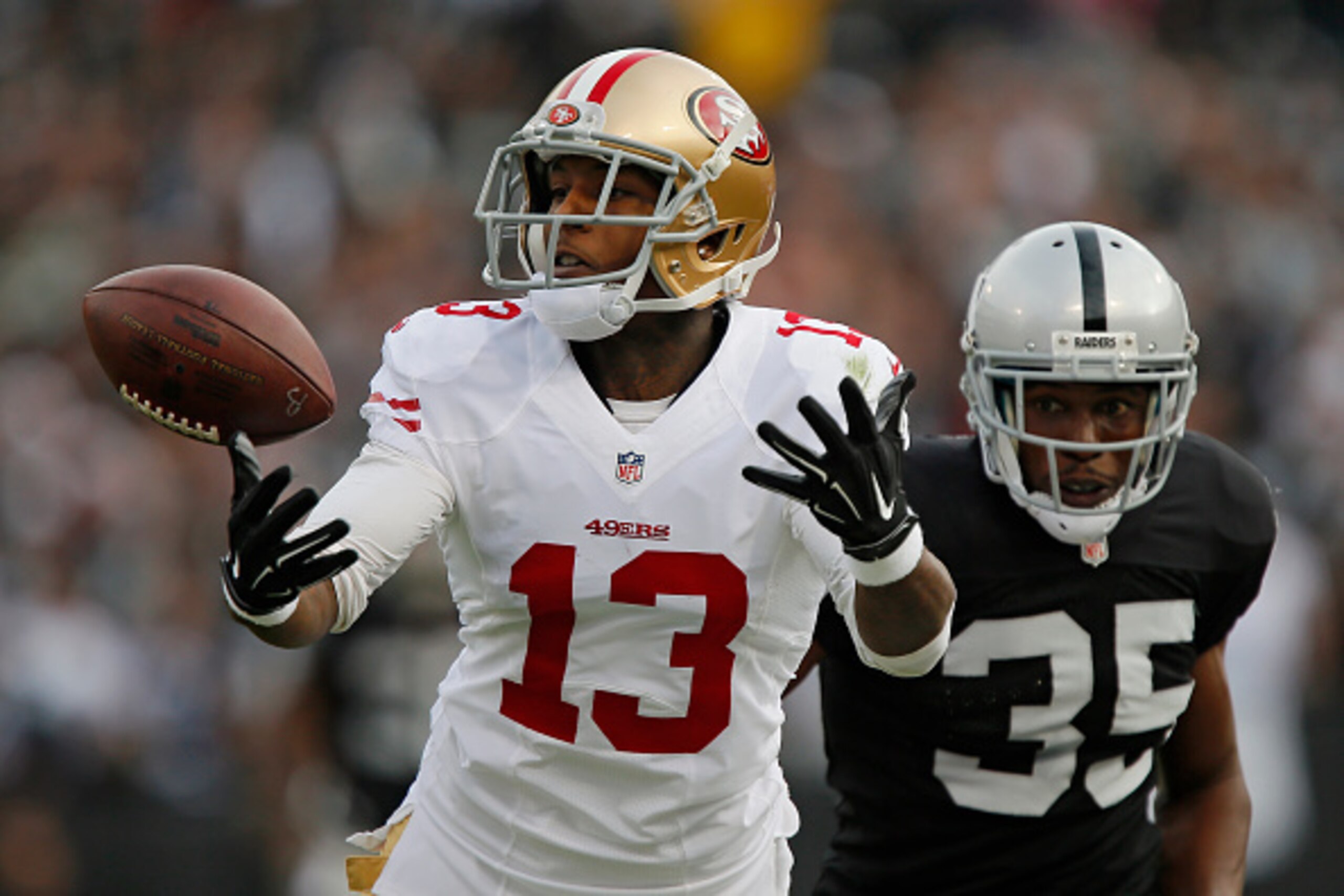 OAKLAND, CA - DECEMBER 7:  Wide receiver Stevie Johnson #13 of the San Francisco 49ers tries unsuccessfully to pull down a pass against cornerback Chimdi Chekwa #35 of the Oakland Raiders in the second quarter on December 7, 2014 at O.co Coliseum in Oakla