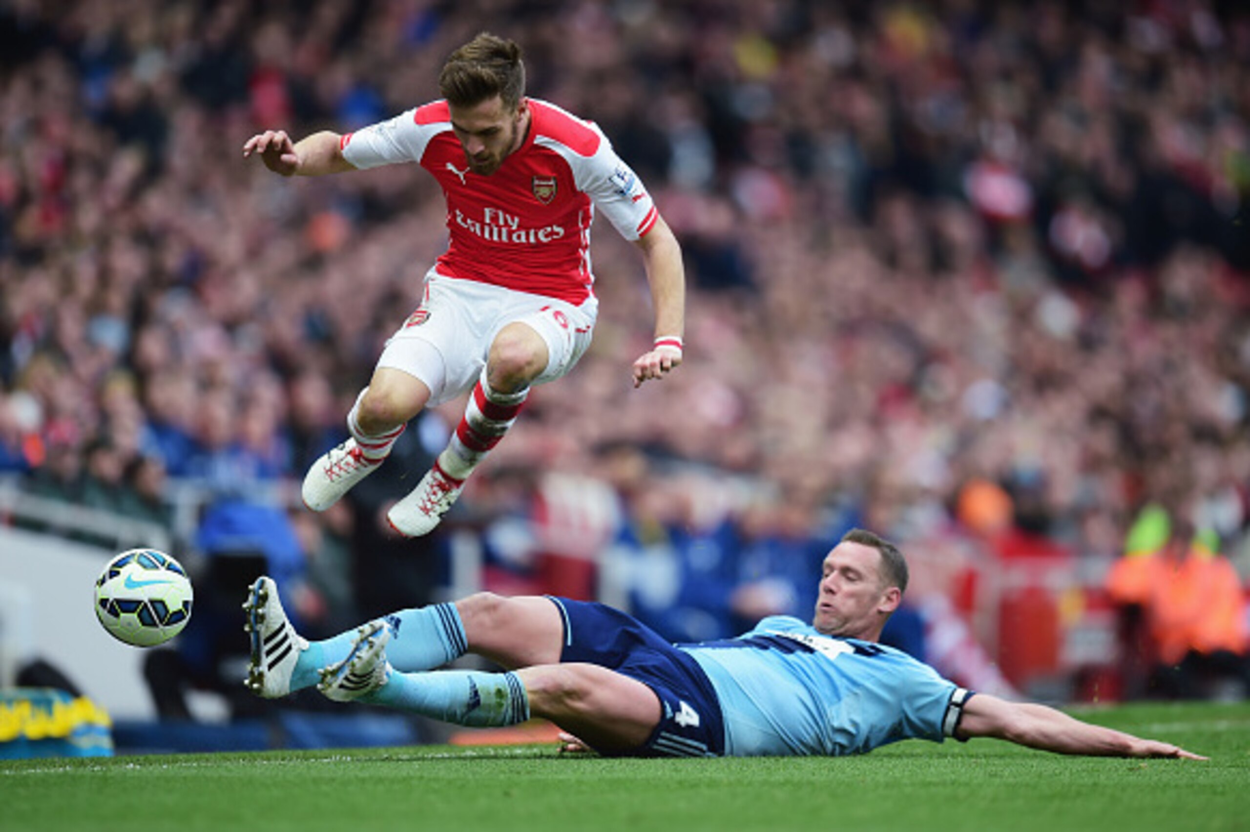 LONDON, ENGLAND - MARCH 14:  Aaron Ramsey of Arsenal is challenged by Kevin Nolan of West Ham United during the Barclays Premier League match between Arsenal and West Ham United at Emirates Stadium on March 14, 2015 in London, England.  (Photo by Jamie Mc