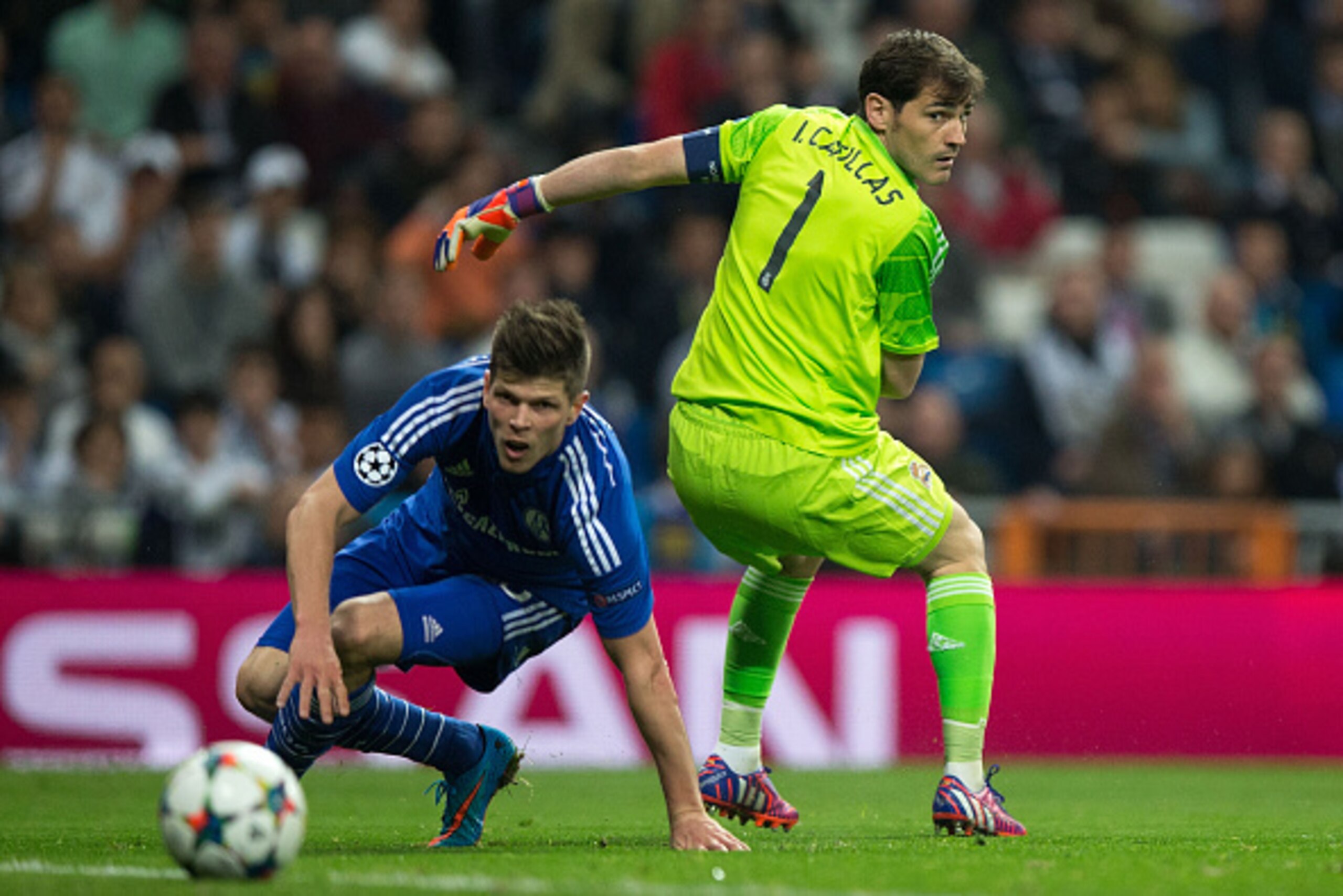 MADRID, SPAIN - MARCH 10: Klaas-Jan Huntelaar (L) of FC Schalke 04 overtakes goalkeeper Iker Casillas (R) of Real Madrid CF during the UEFA Champions League round of 16 second leg match between Real Madrid CF and FC Schalke 04 at Estadio Santiago Bernabeu